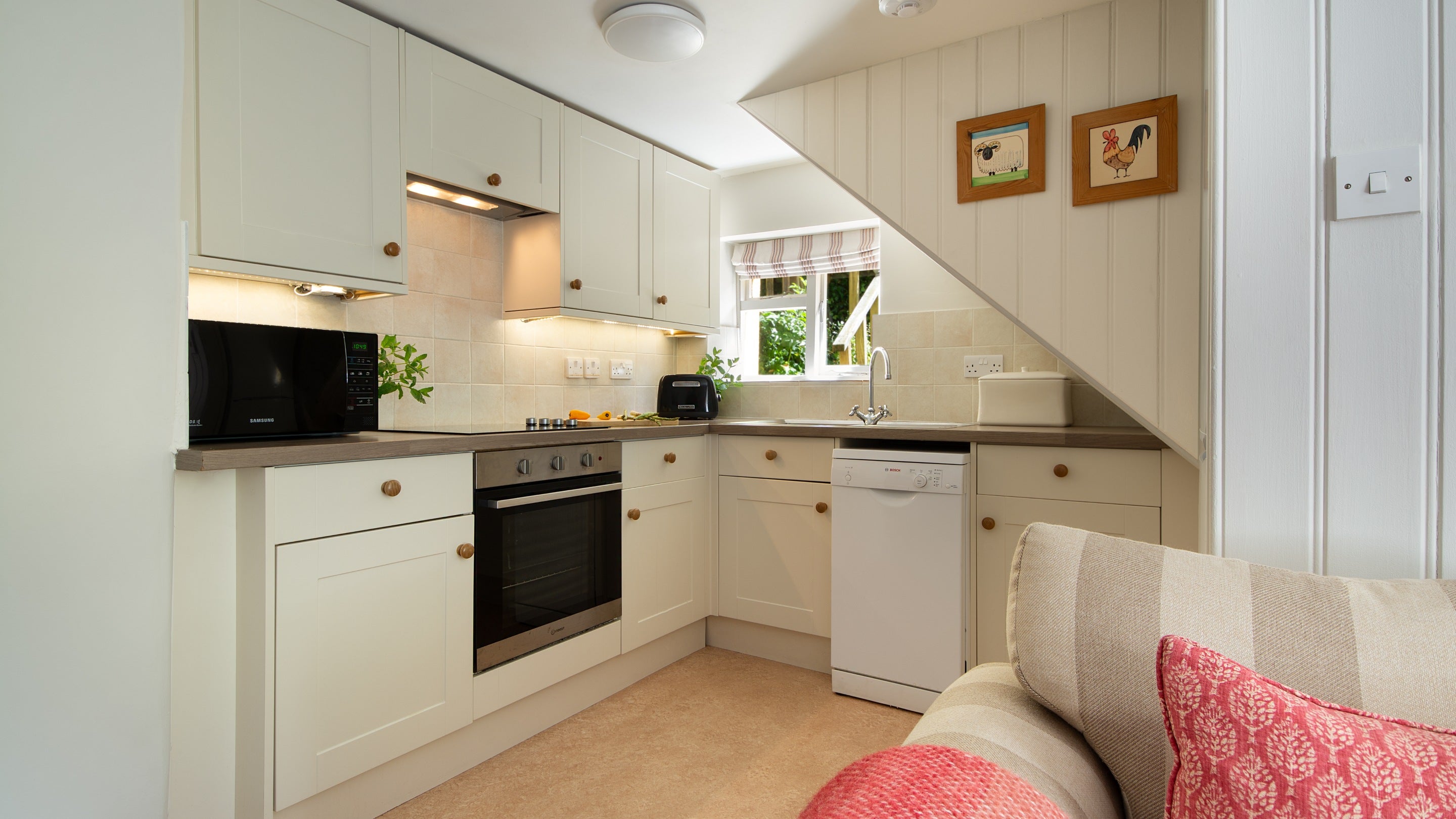 The kitchen area at Crockers Cottage, with cooker, hob, microwave, toaster and dishwasher, Devon