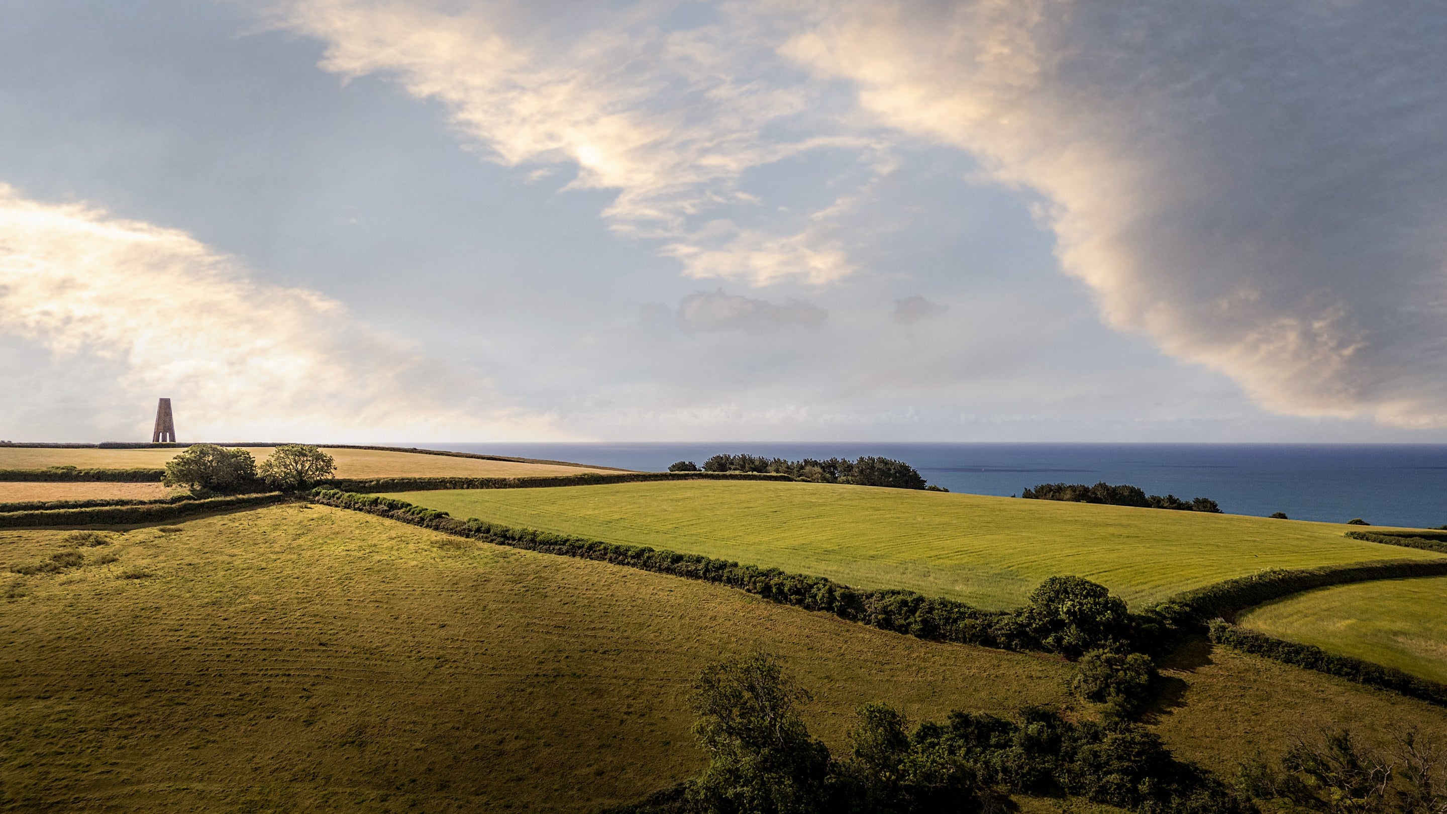 The countryside near Crockers Cottage, with the Daymark landmark and sea in the distance, Devon