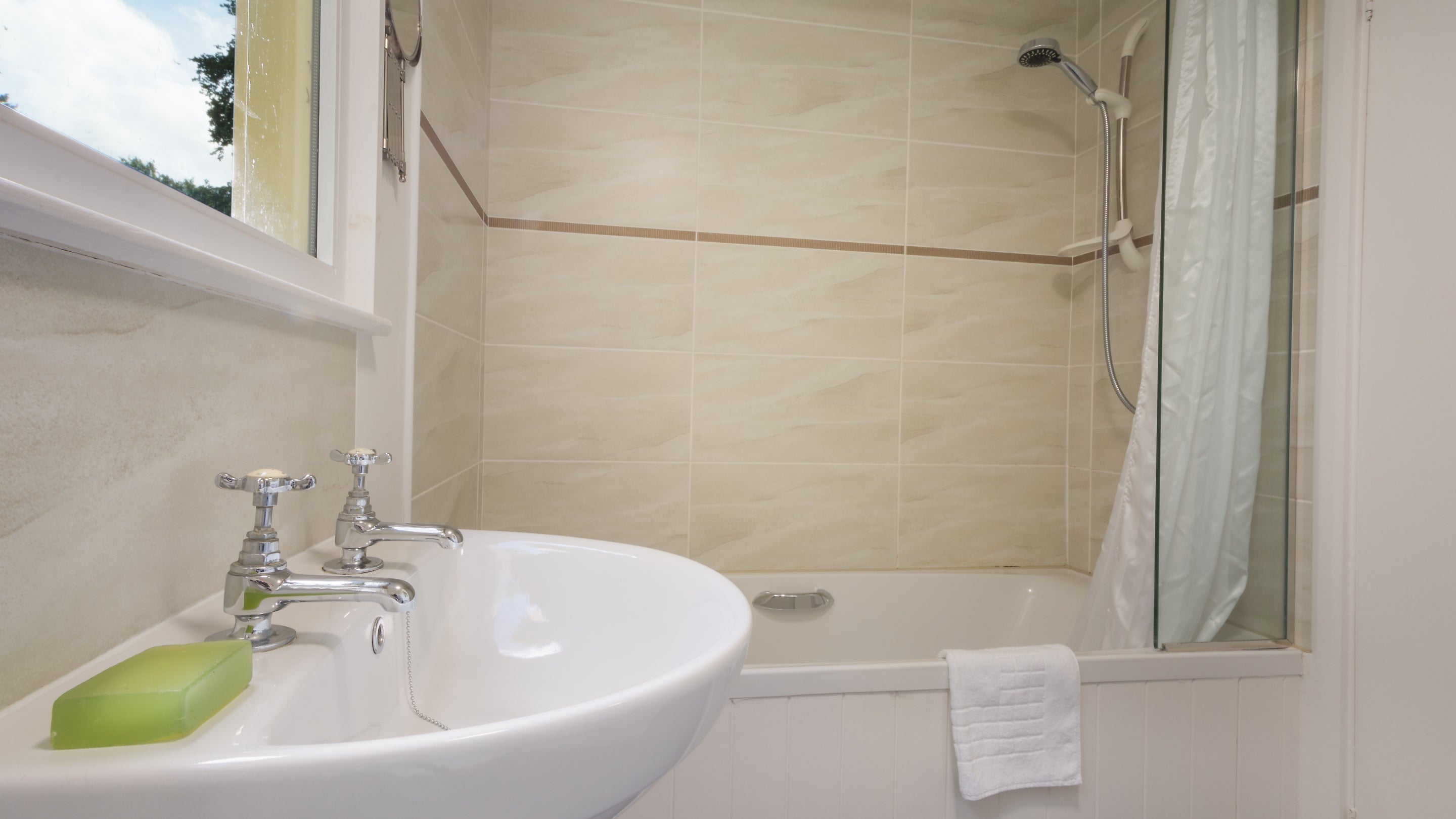 The bathroom with shower over bath at Warcleave Cottage, Devon
