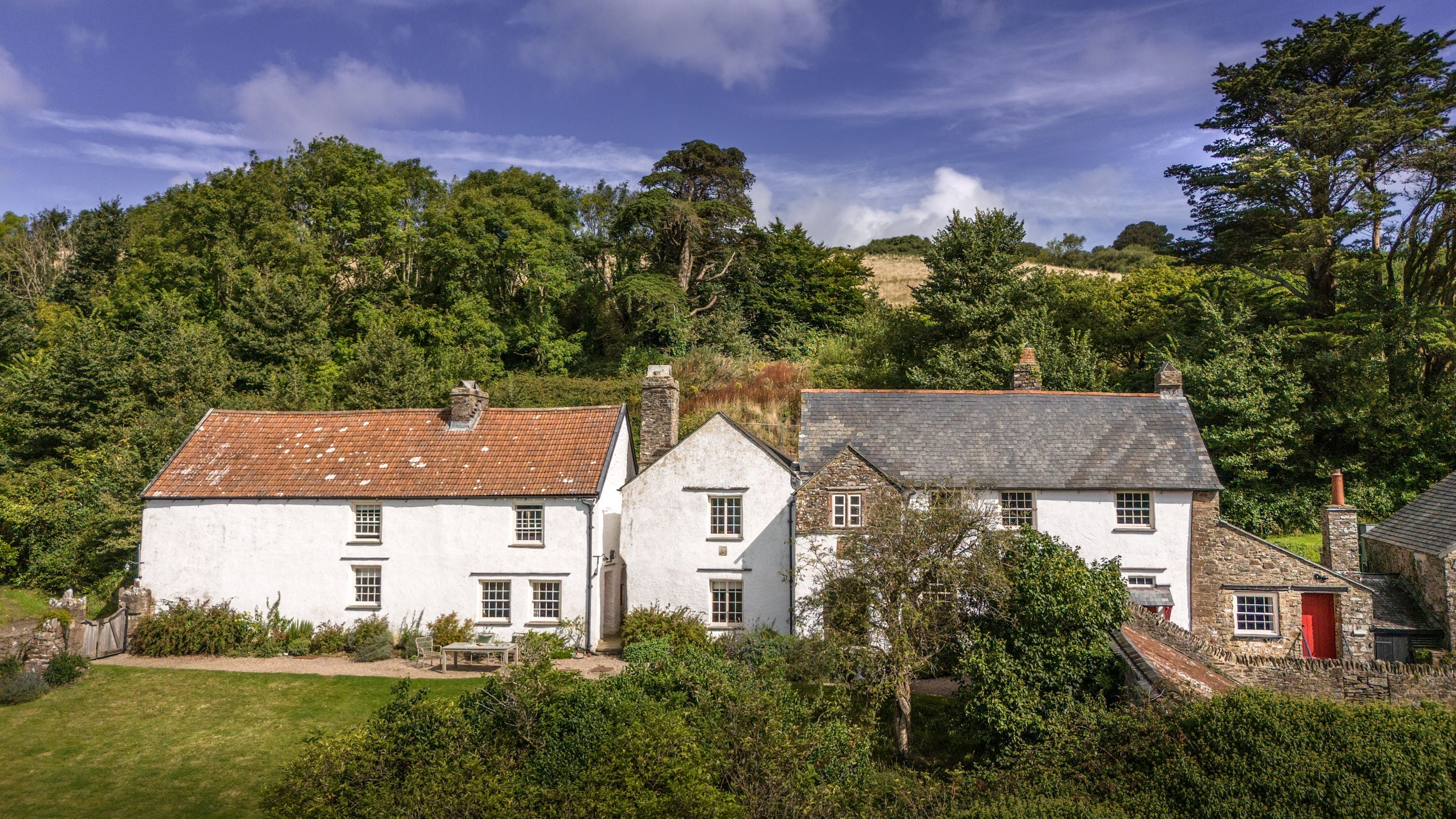 An aerial view of West Challacombe Manor on the right and neighbouring West Challacombe Cottage on the left, Devon