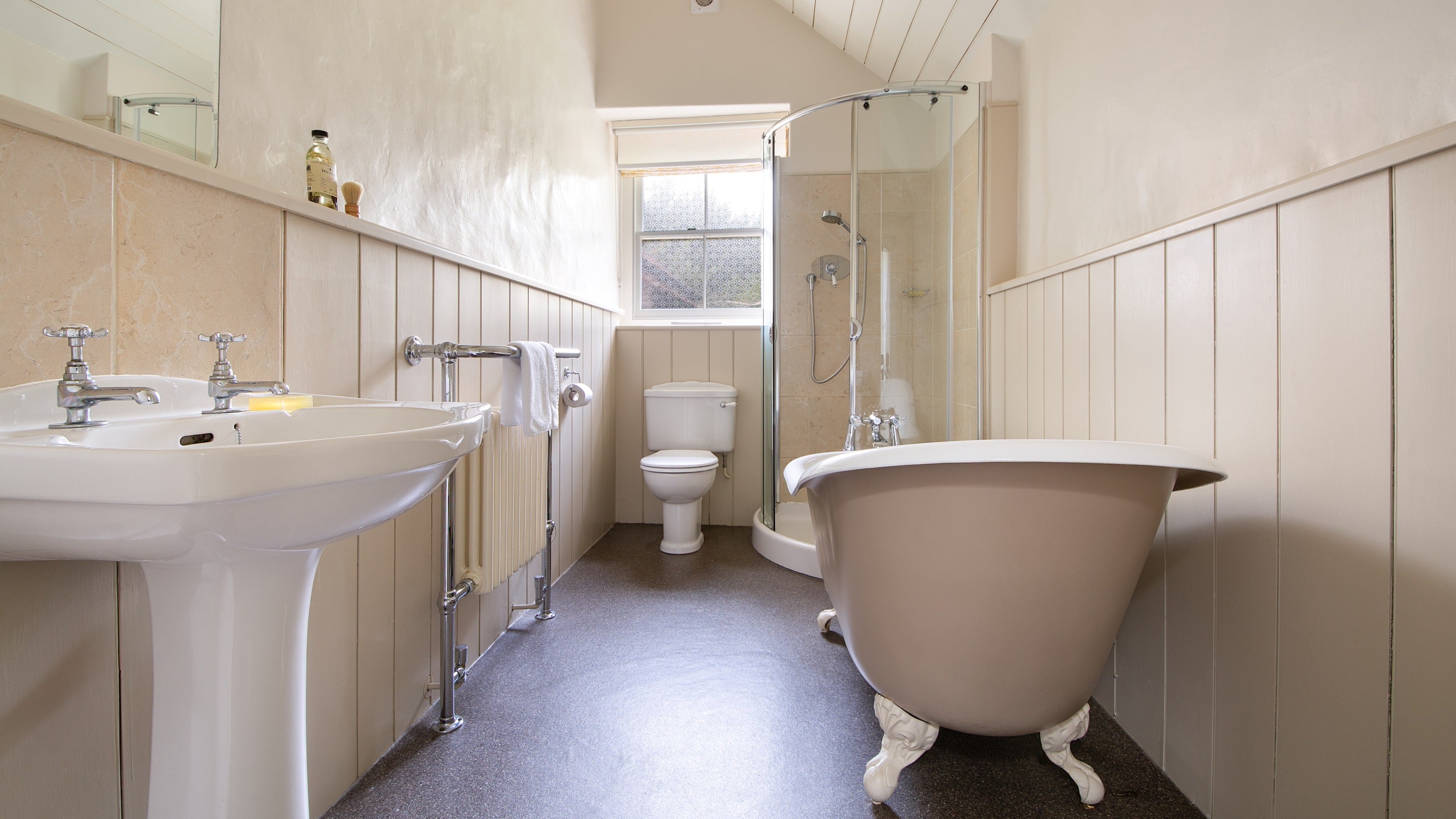 The bathroom with roll-top bath and freestanding shower at West Challacombe Manor, Devon