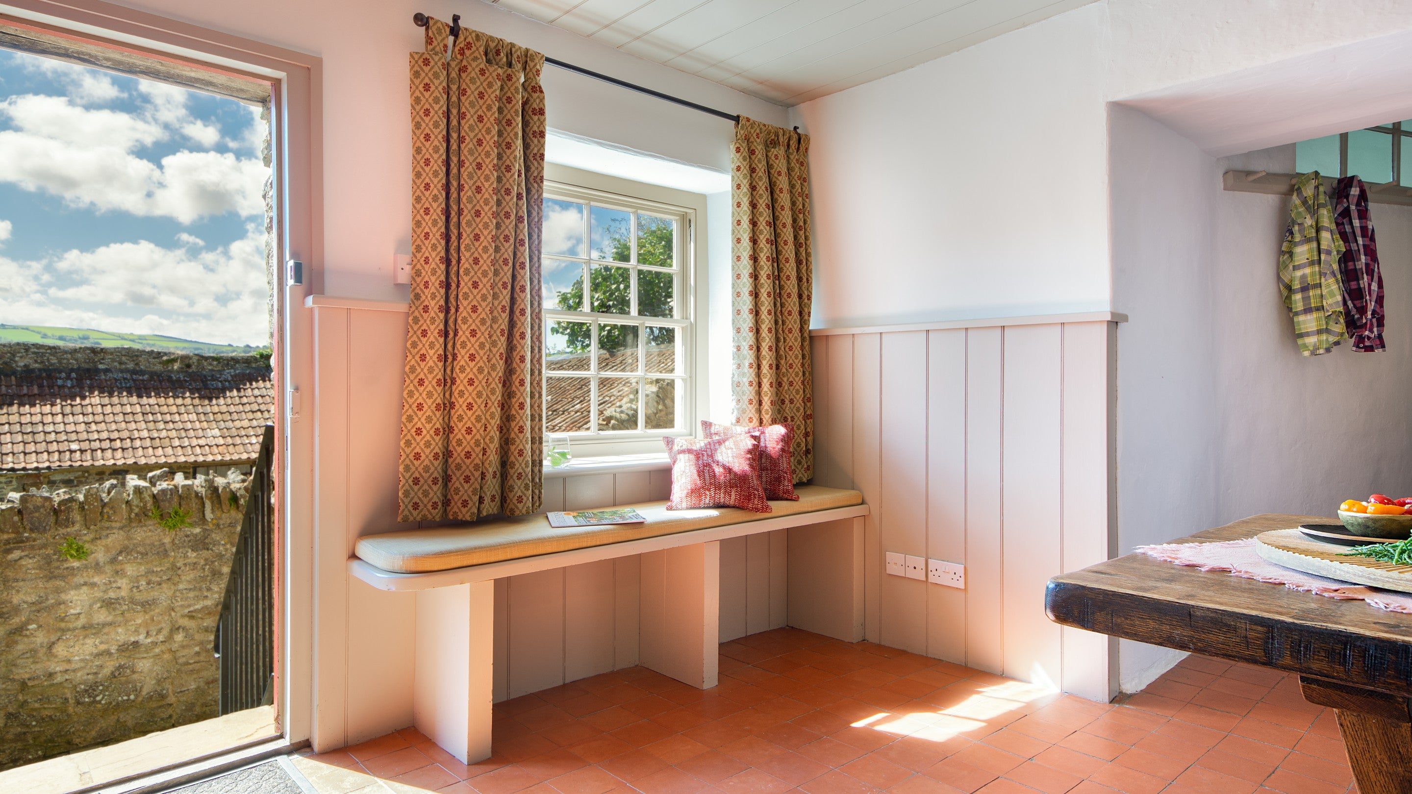The main door, with bench seating next to it, in the dining room at West Challacombe Manor, Devon