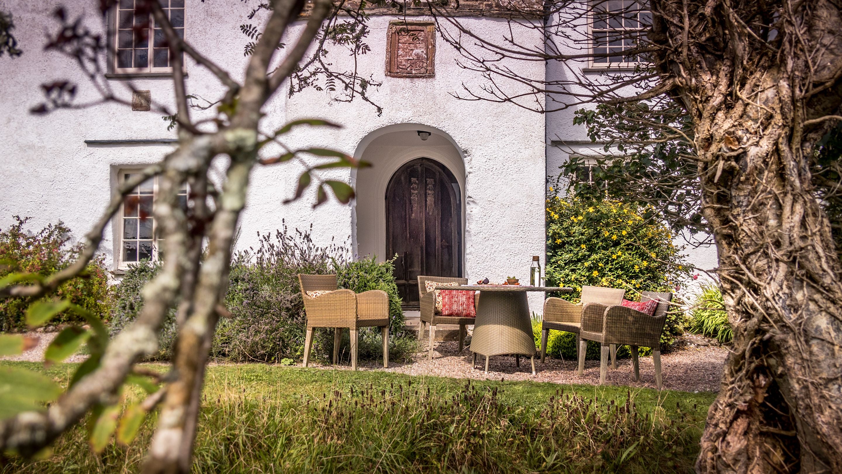 The front garden with outdoor dining furniture at West Challacombe Manor, Devon