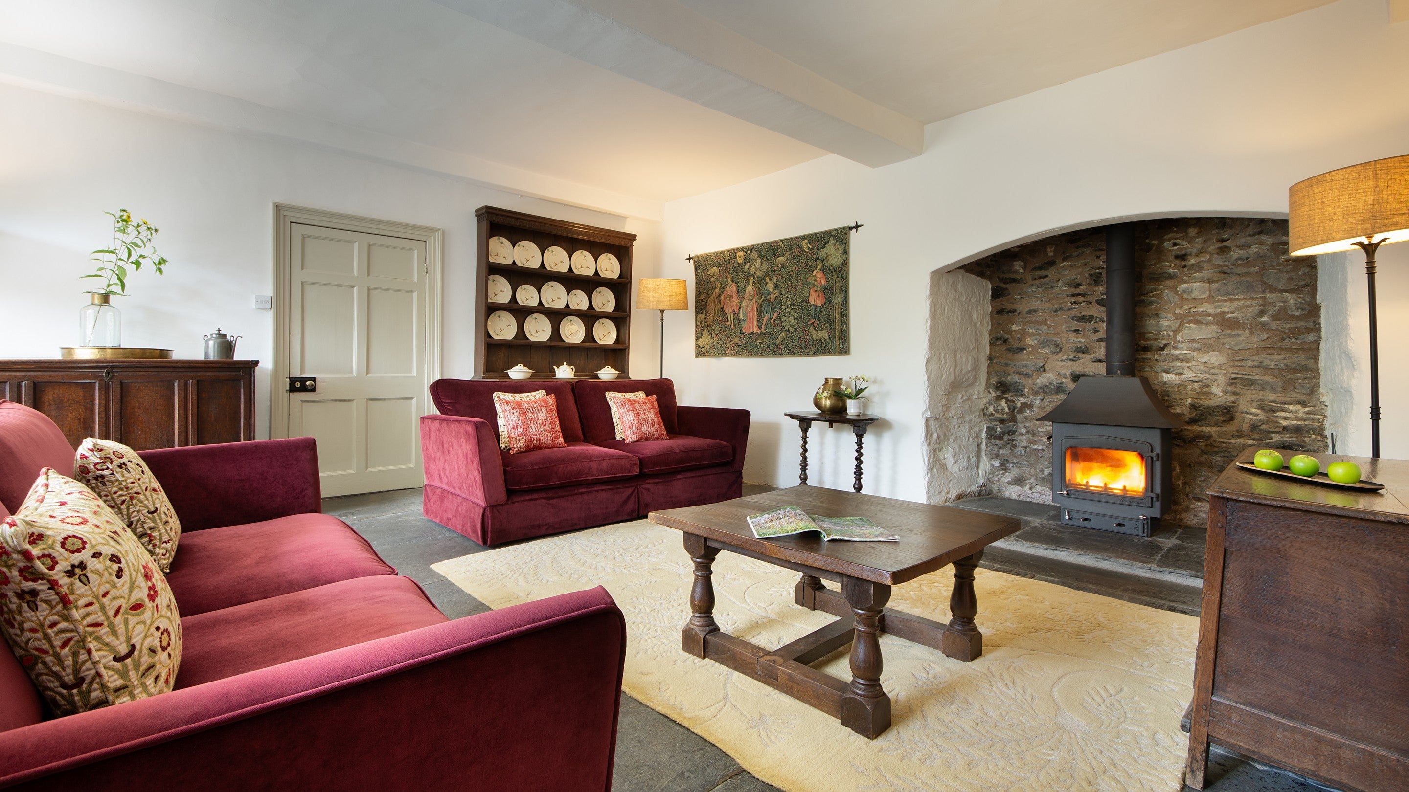 The ground-floor sitting room, with inglenook and woodburner, at West Challacombe Manor, Devon