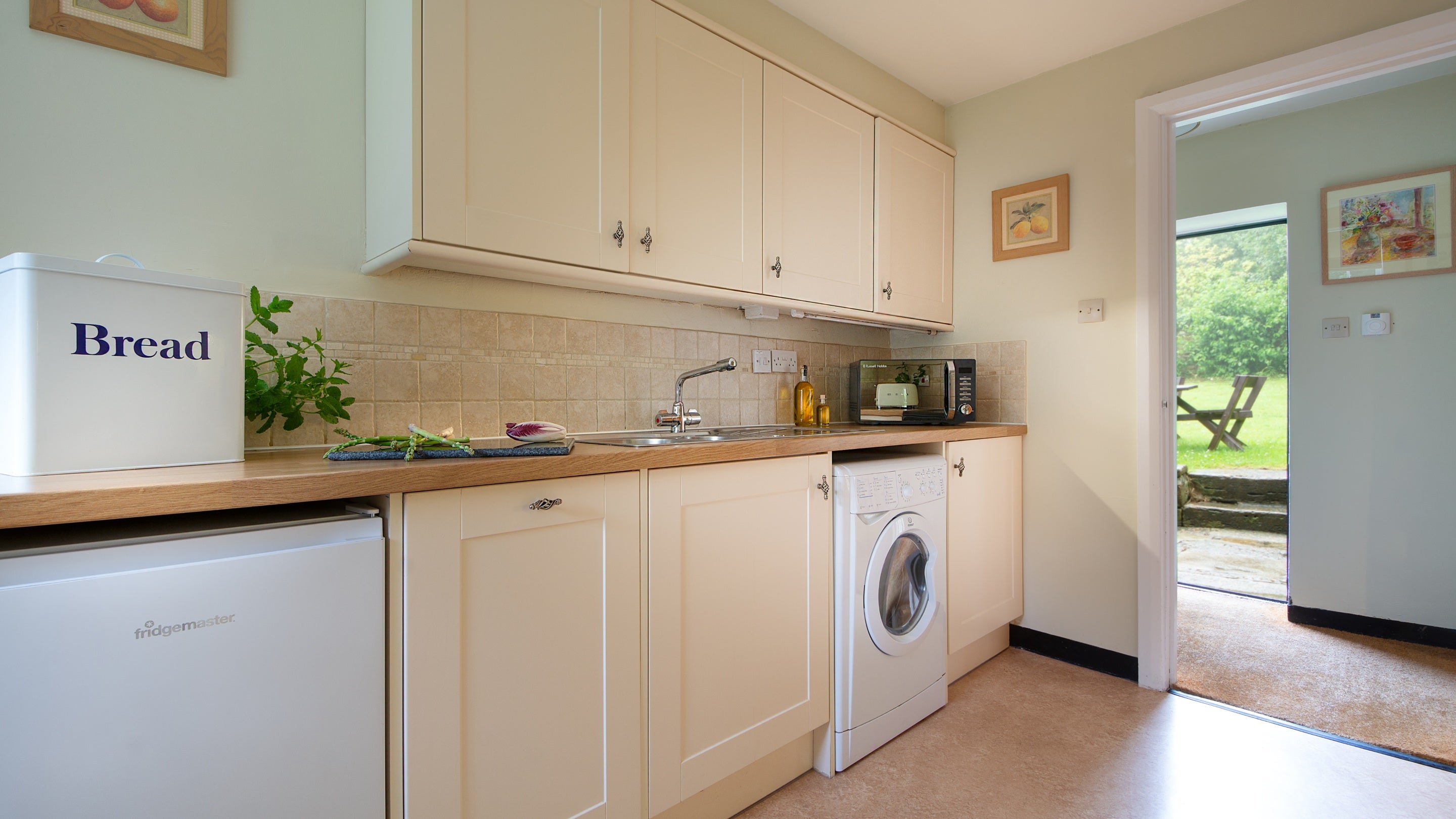 The kitchen, including microwave, dishwasher and washing machine, and the entrance hall at Ash Cottage, Dorset