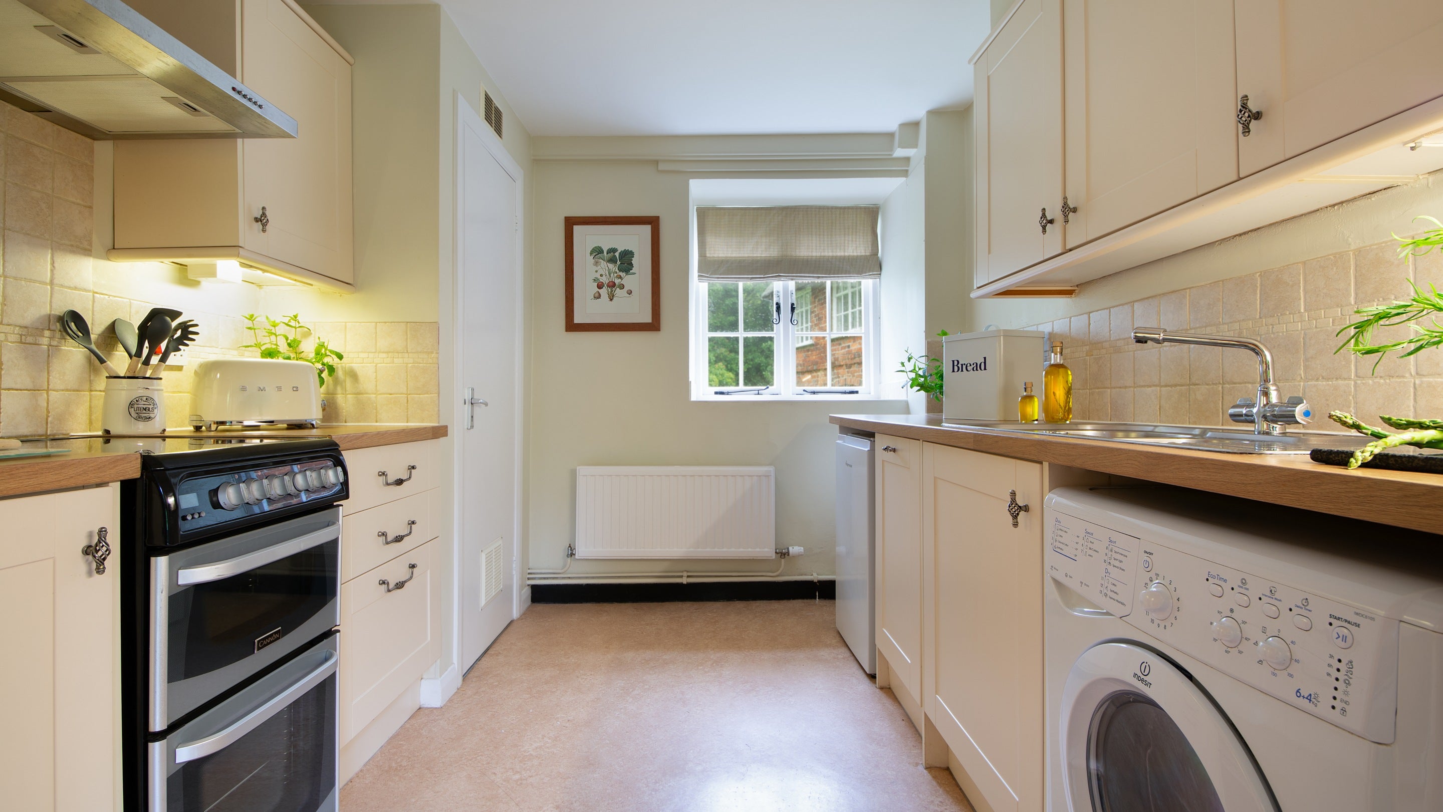 The kitchen, including cooker, hob, toaster and washing machine, at Ash Cottage, Dorset