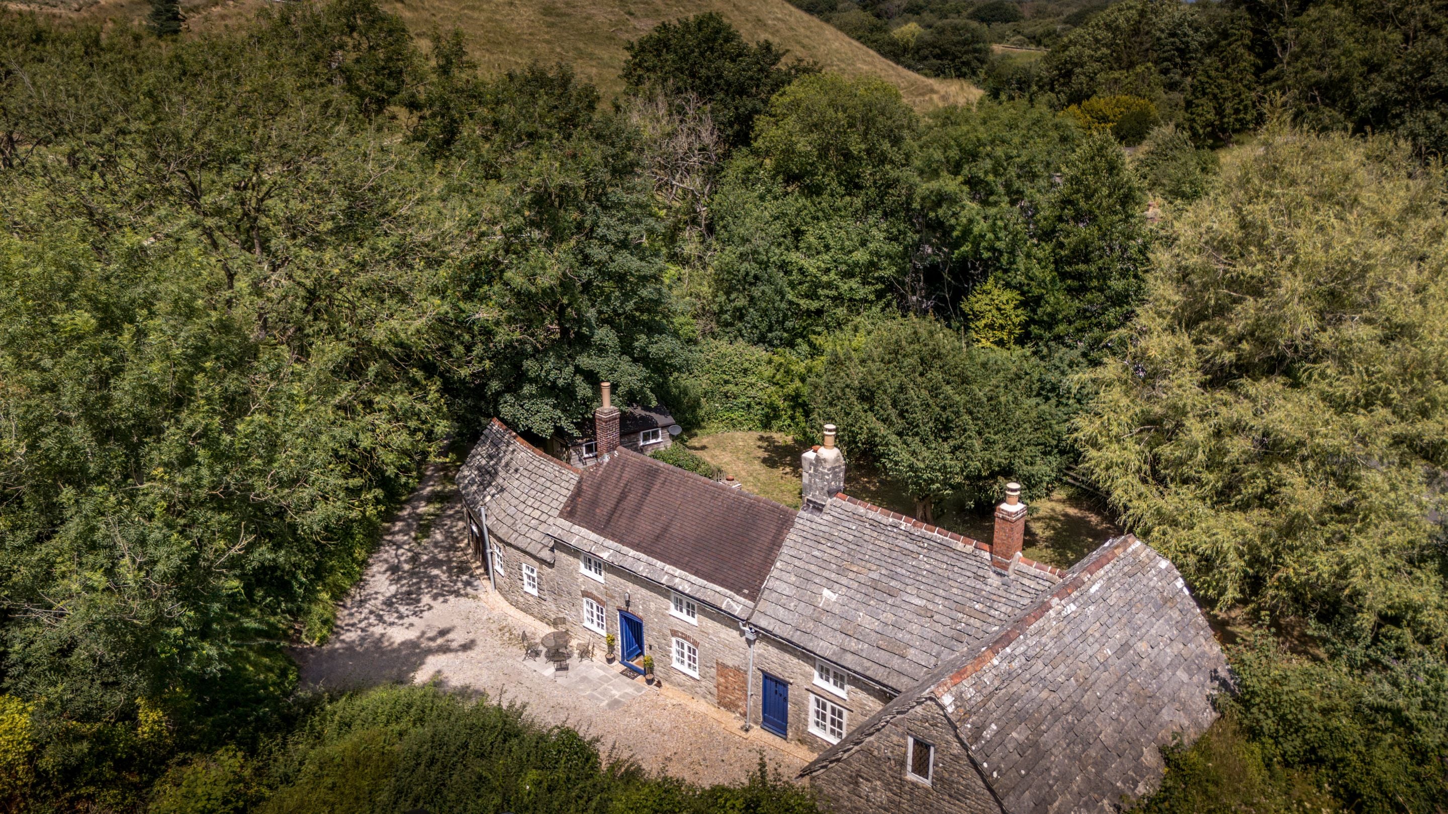 An aerial view of Boar Mill Cottage, surrounded by trees, Dorset