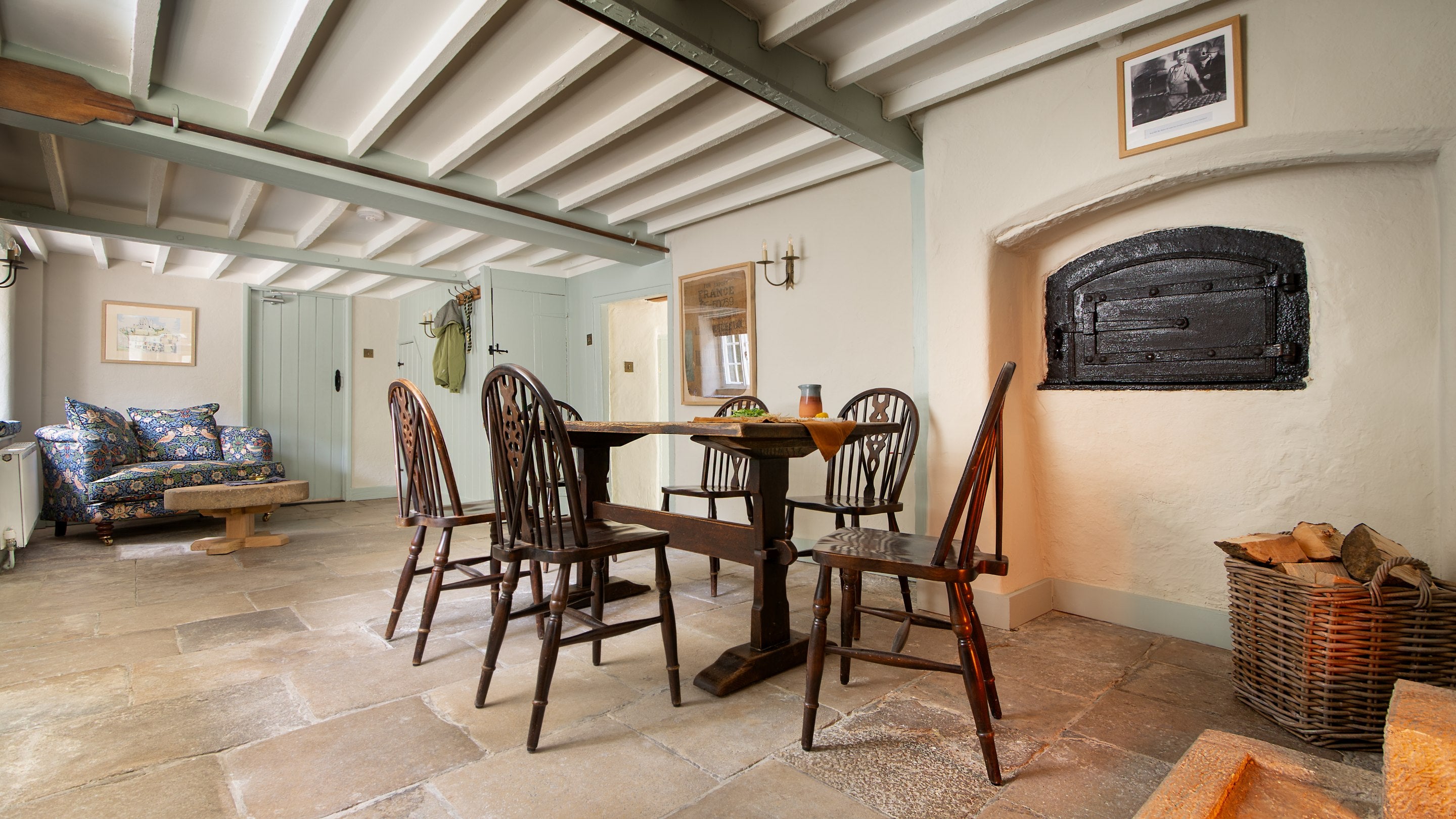 The dining room with woodburner, original bread oven and stone floor at Boar Mill Cottage, Dorset