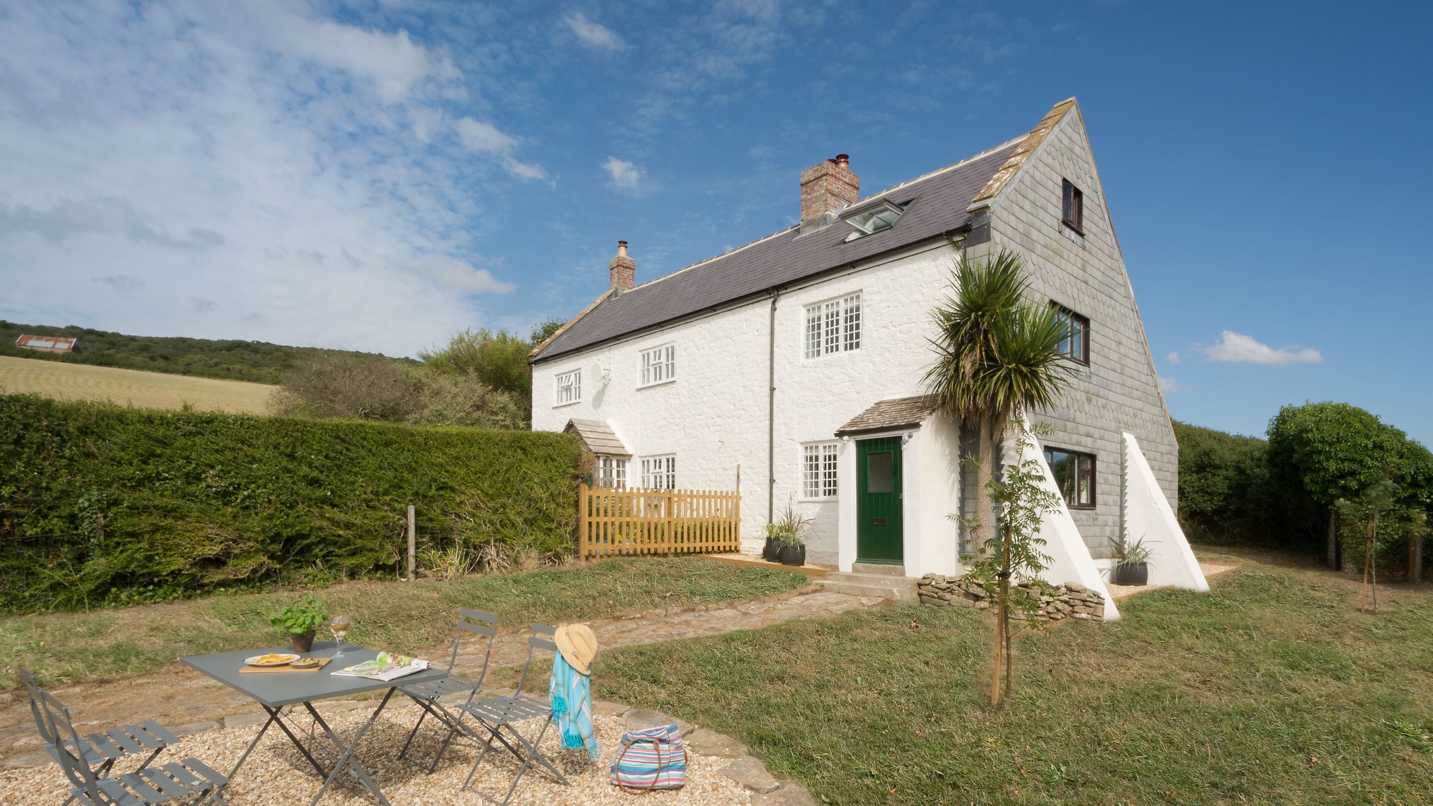 The garden at Chesil Cottage, with lawn and outdoor dining furniture, Dorset