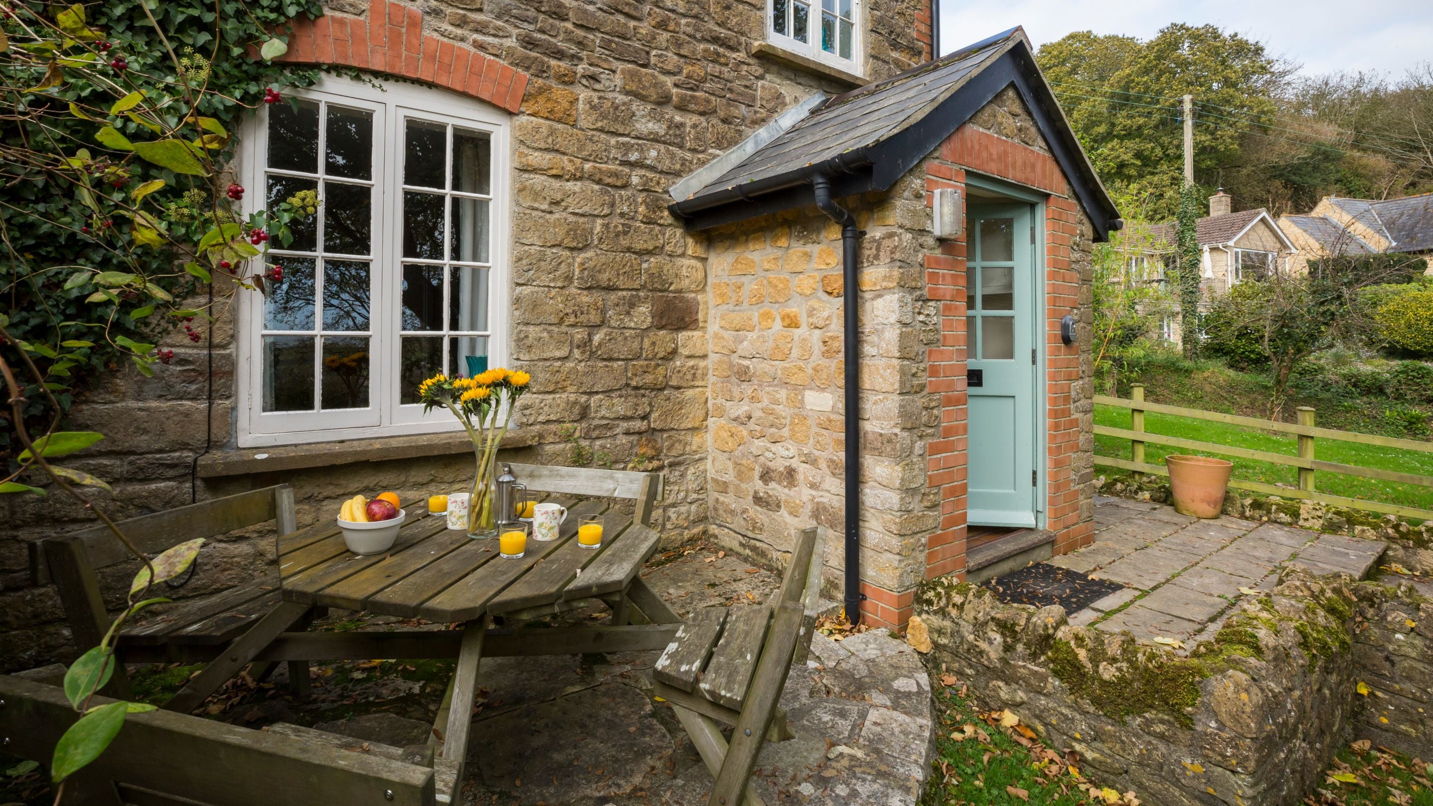 Outdoor table and chairs on the patio at Downhouse Farm Cottage, Dorset