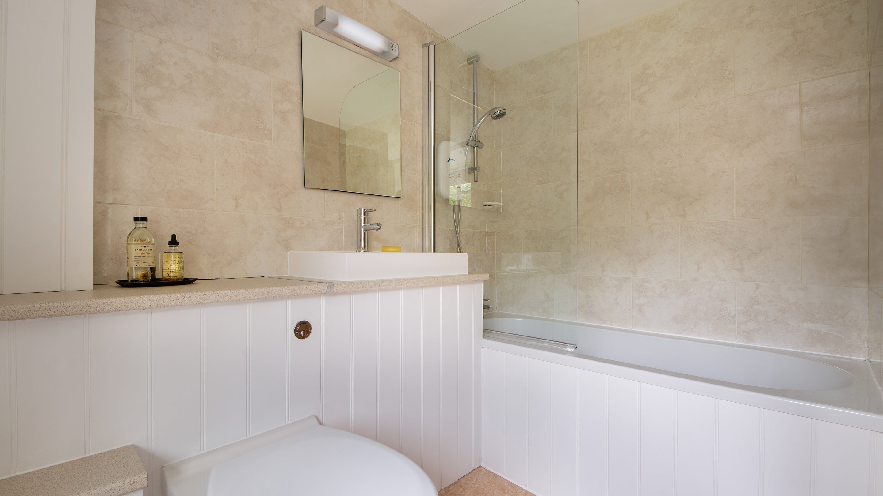 The en-suite bathroom with shower over bath at Oak Cottage, Dorset