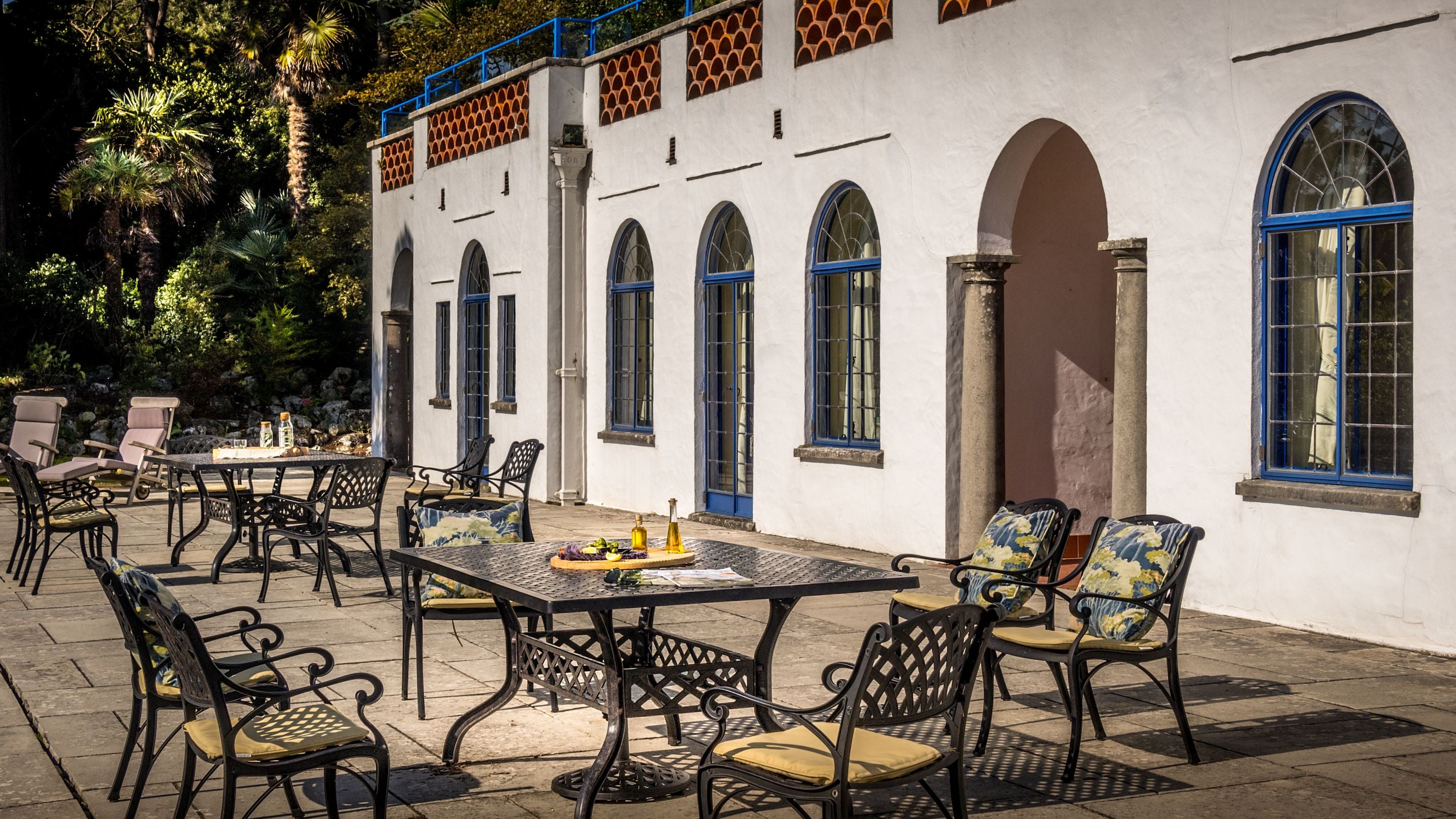 The lower terrace, with outdoor dining furniture, at Portland House, Dorset