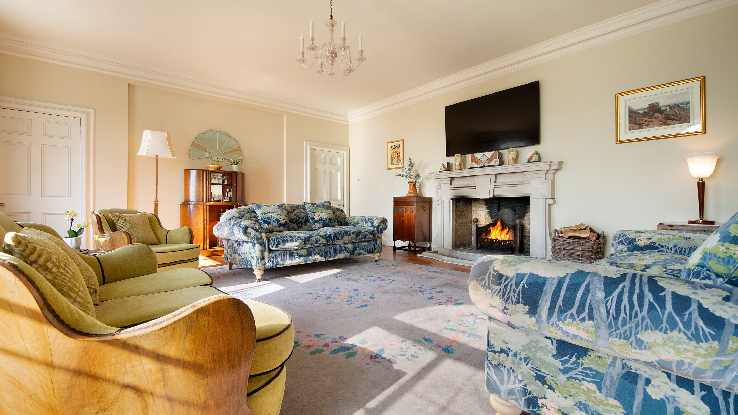 The drawing room at Portland House, with sofas, television and an open fire in the Portland Stone fireplace, Dorset