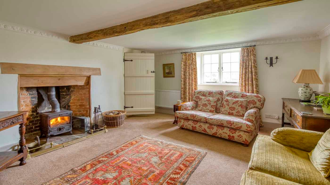 The snug at Shedbush Farmhouse with sofas, woodburner and television, nr Bridport, Dorset