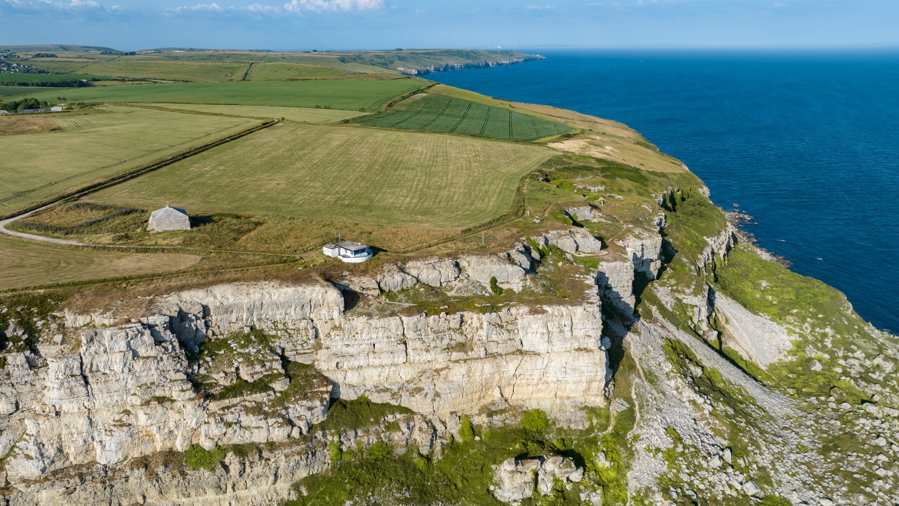 An aerial view of the coastal cliffs of St. Aldhelm's Head, a 40-minute walk from Weston Farm Campsite, Dorset