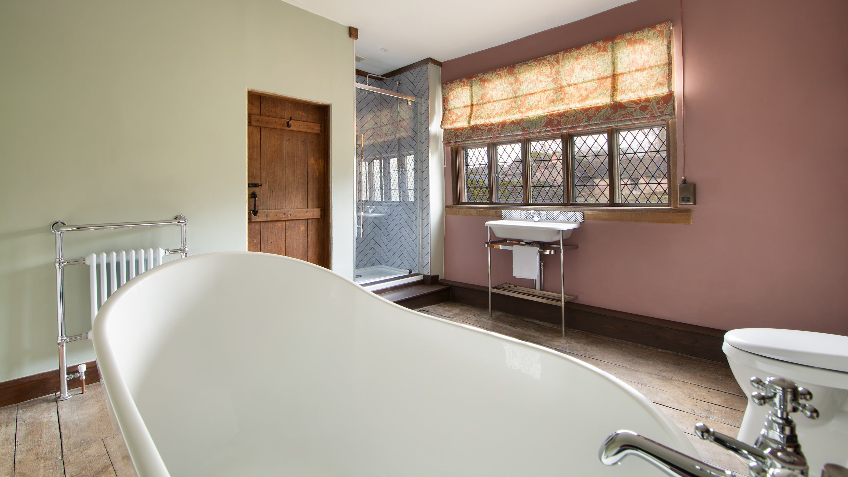 One of the bathrooms at Cwmmau Farmhouse with roll-top bath and walk-in shower, Herefordshire