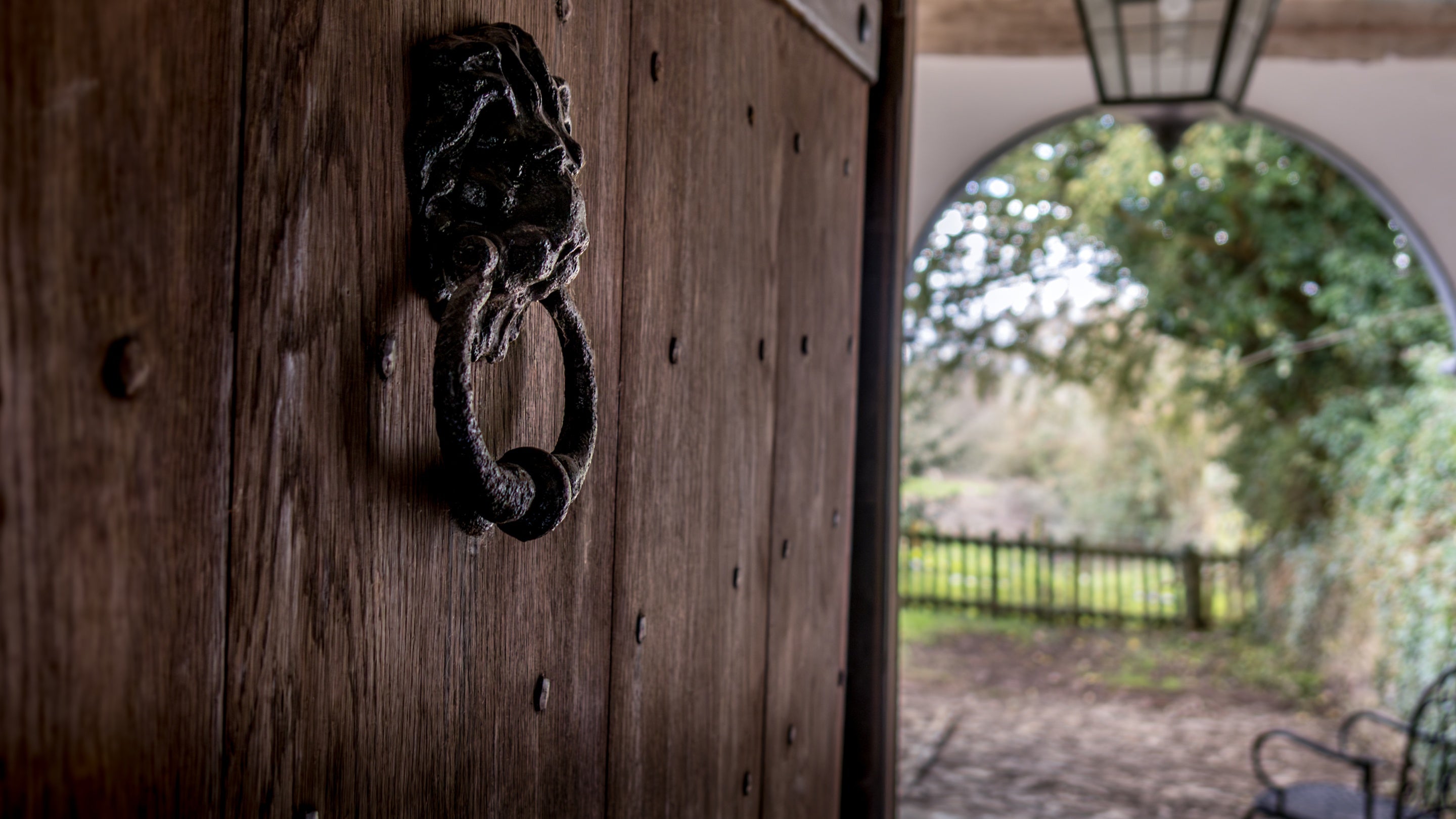 The old wooden door from the porch at Cwmmau Farmhouse,  with door knocker shaped like a lion's head, Herefordshire