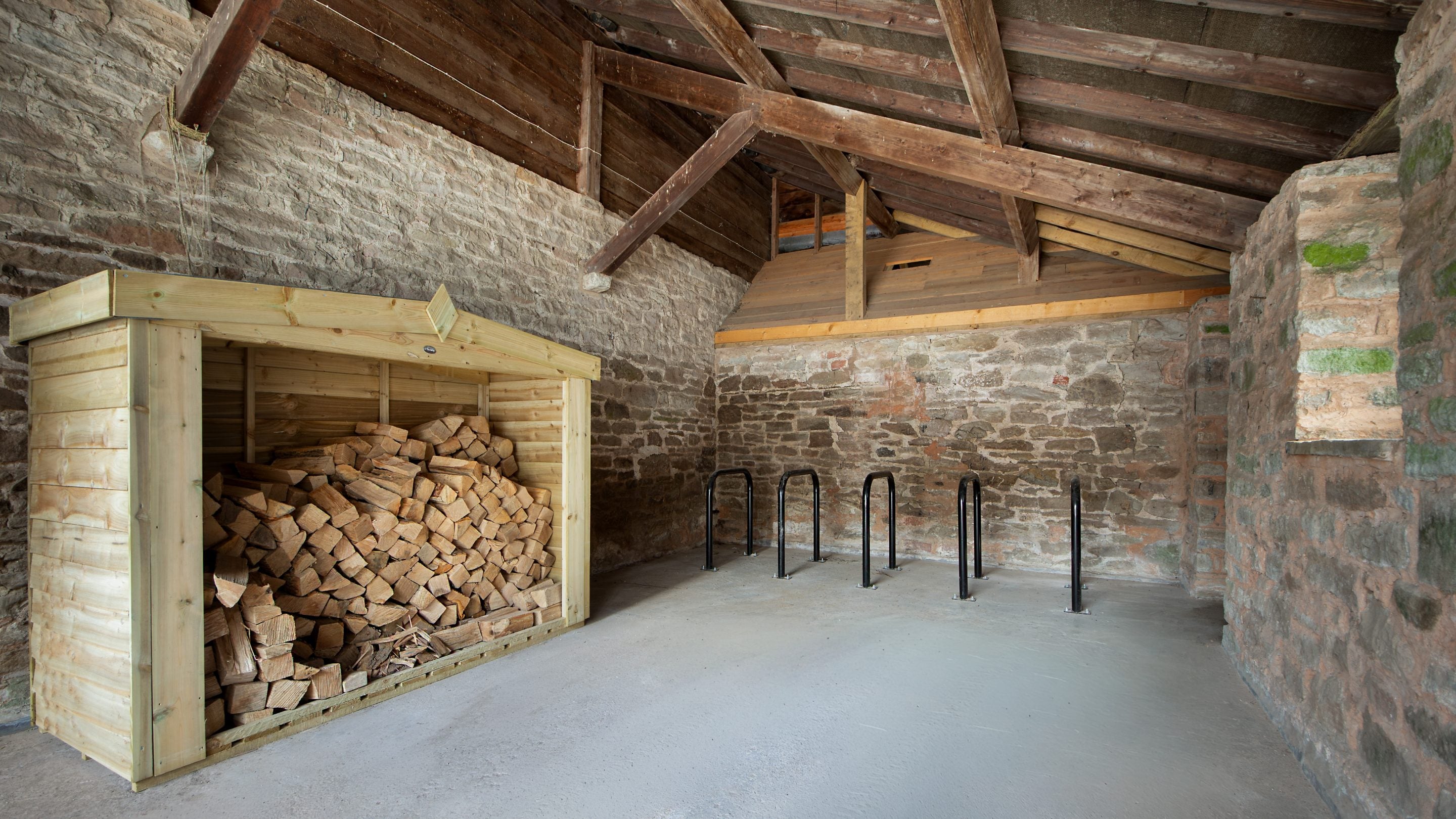 One of the outbuildings at Cwmmau Farmhouse with log store and bike racks, Herefordshire
