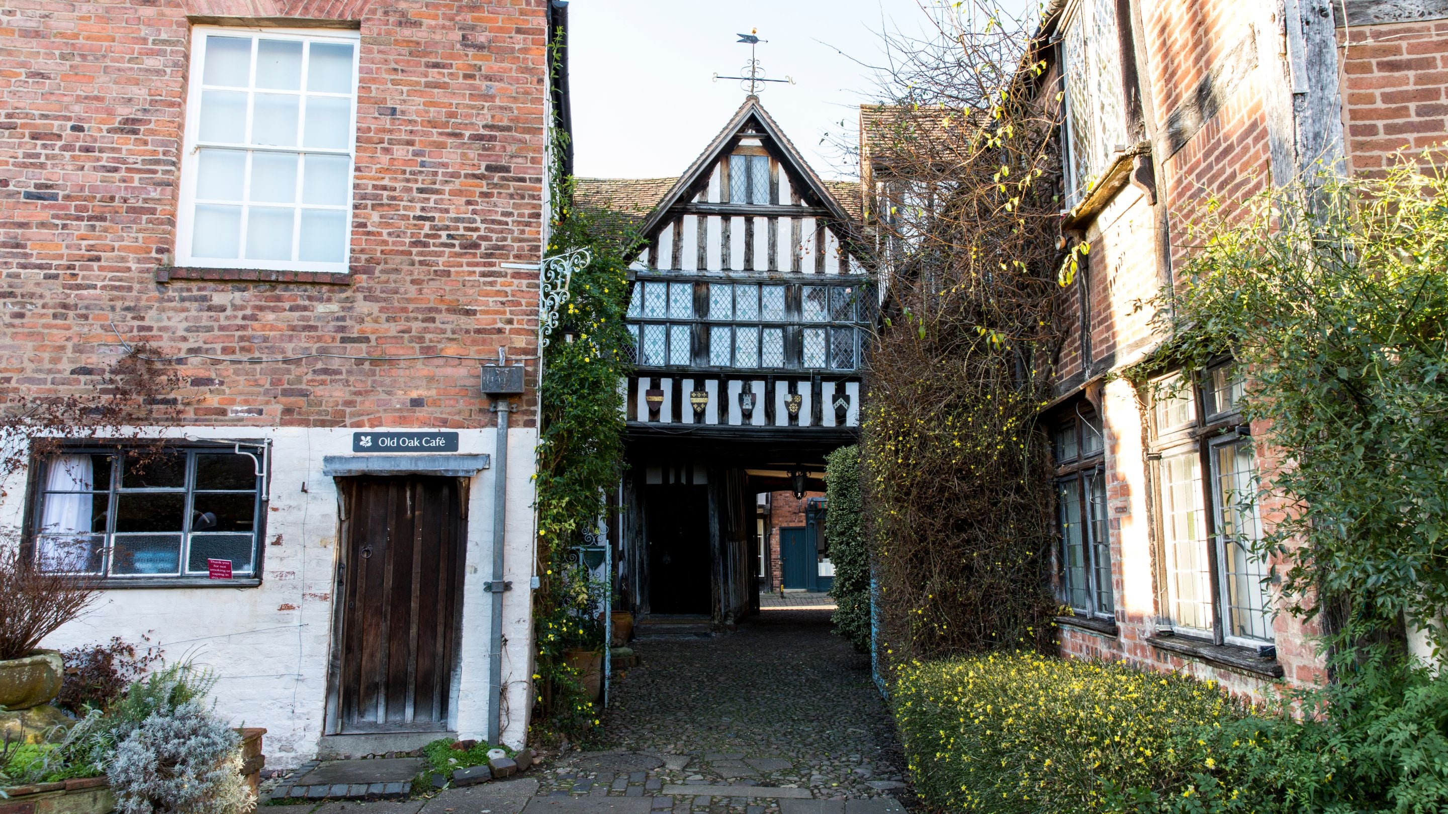 Looking at the back of Greyfriars House from the garden, with the open entrance gate in the background, Worcestershire