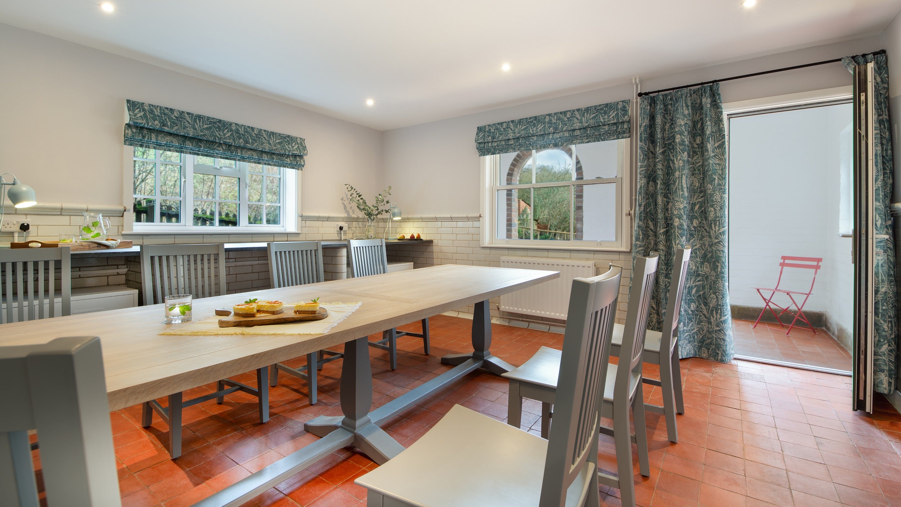 The dining room opens onto the covered veranda at The Weir Garden Cottage, Herefordshire