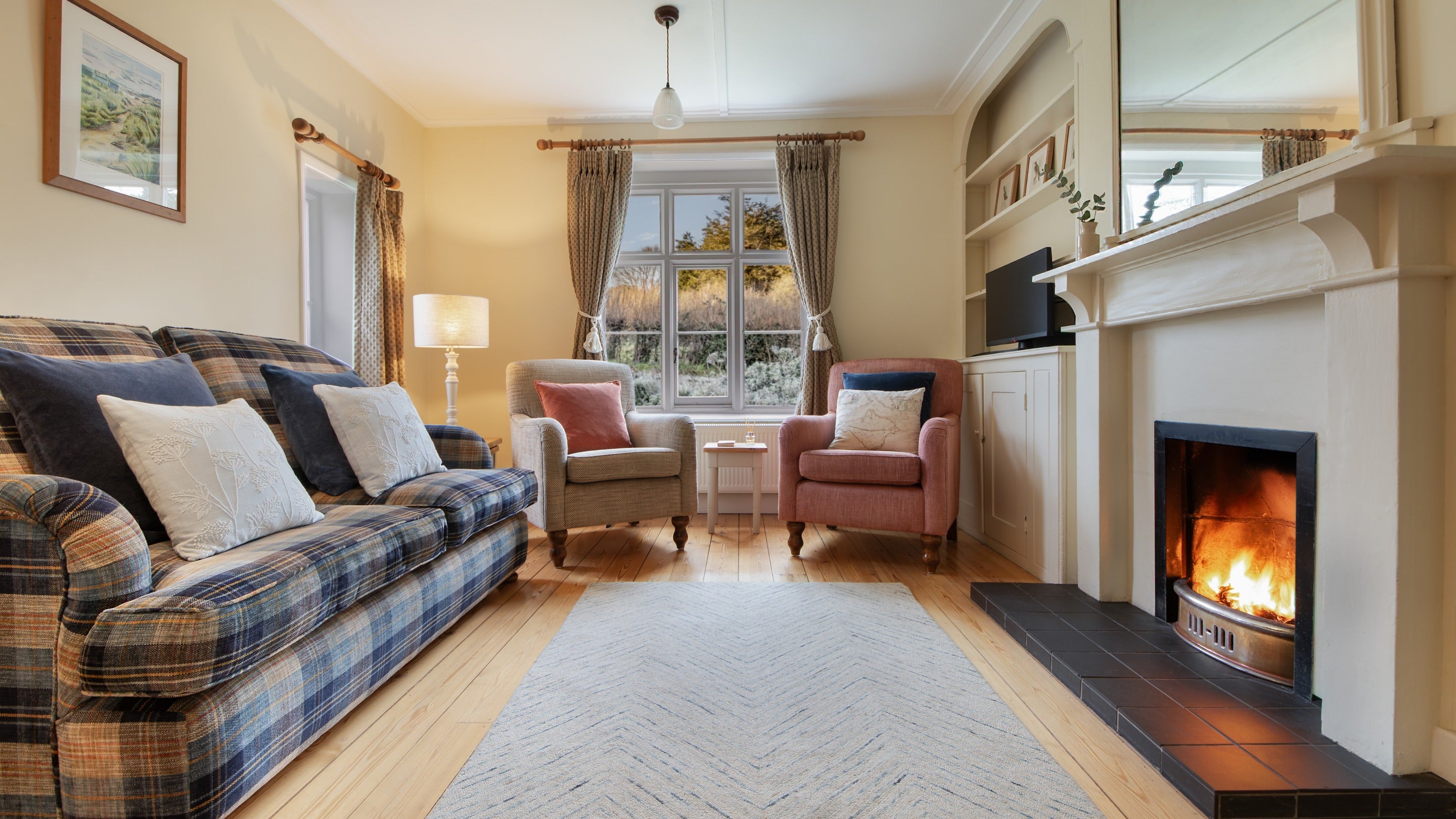 The sitting room with open fire at Old Church Lodge, Isle Of Wight
