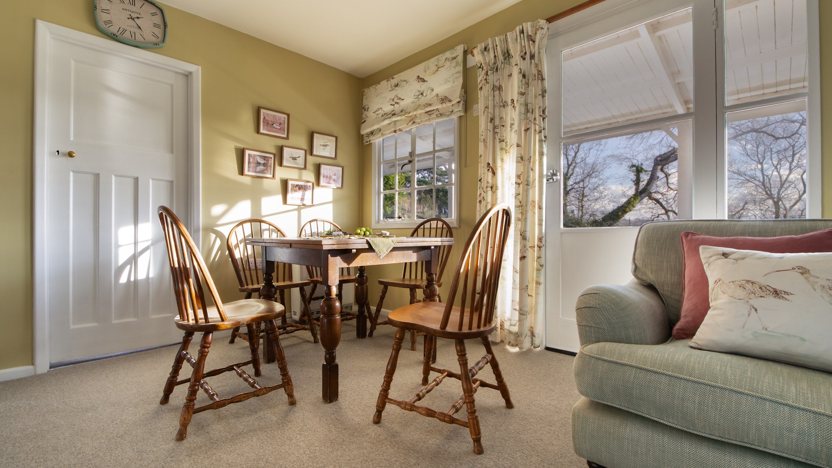 The table in the open-plan sitting and dining room at The Old Clubhouse, with warm light coming through the large windows, Isle Of Wight