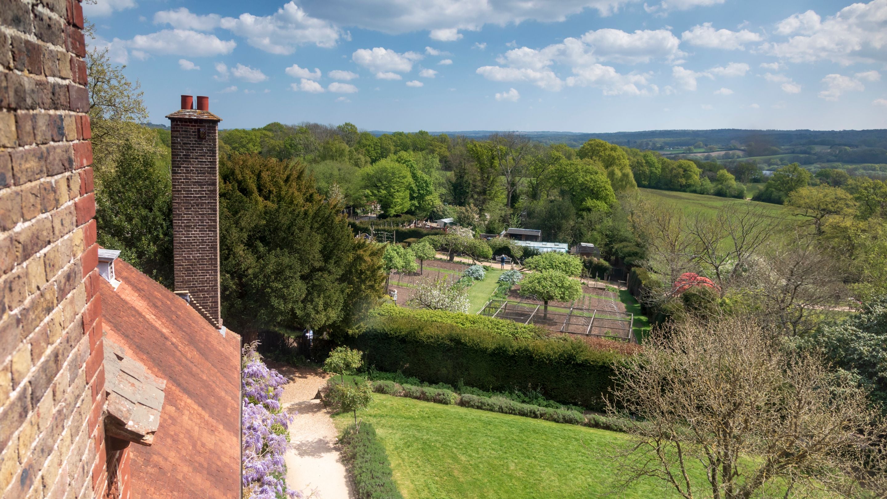 A view from The Morris Apartment, showing part of Standen House's garden and the countryside beyond, West Sussex