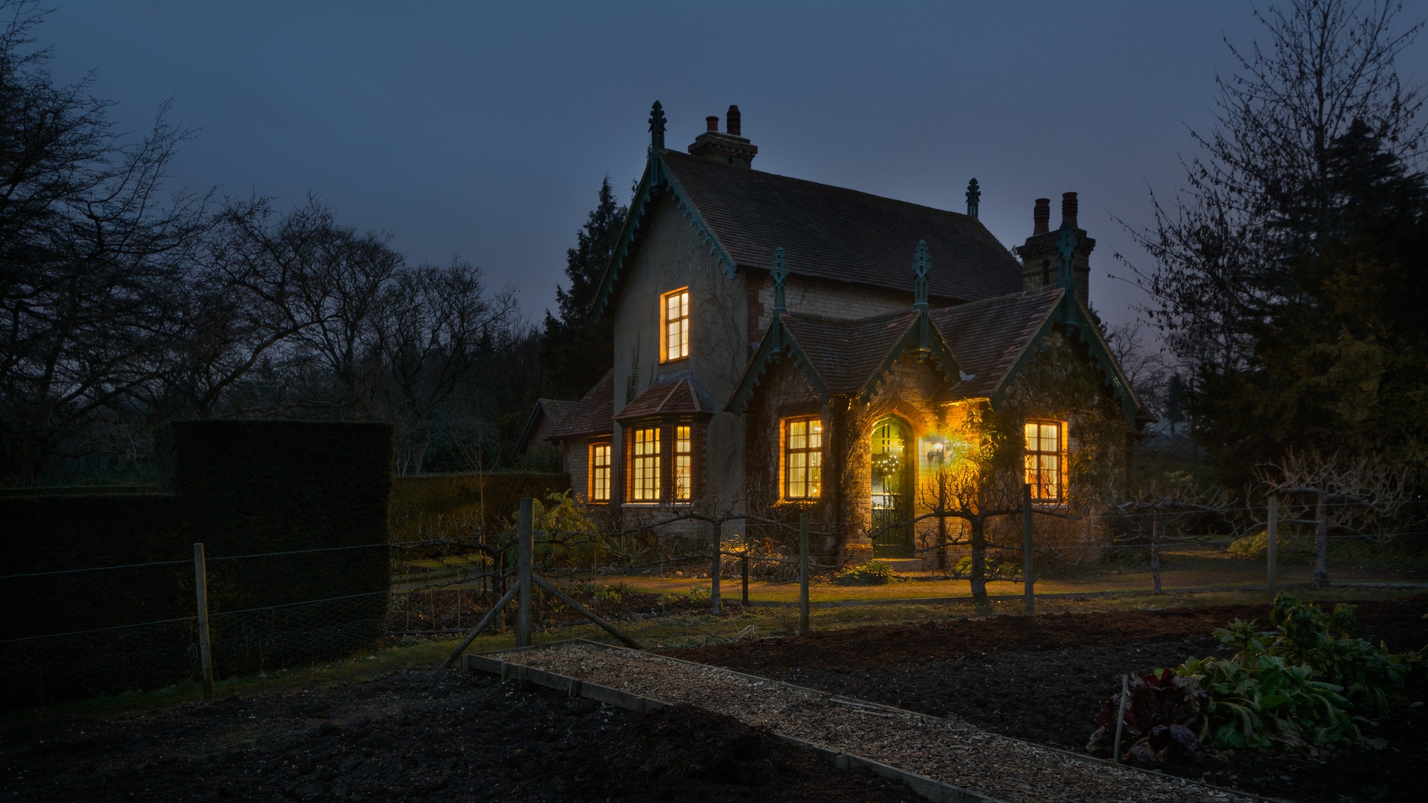 The exterior of Polesden Garden Cottage at night, Surrey