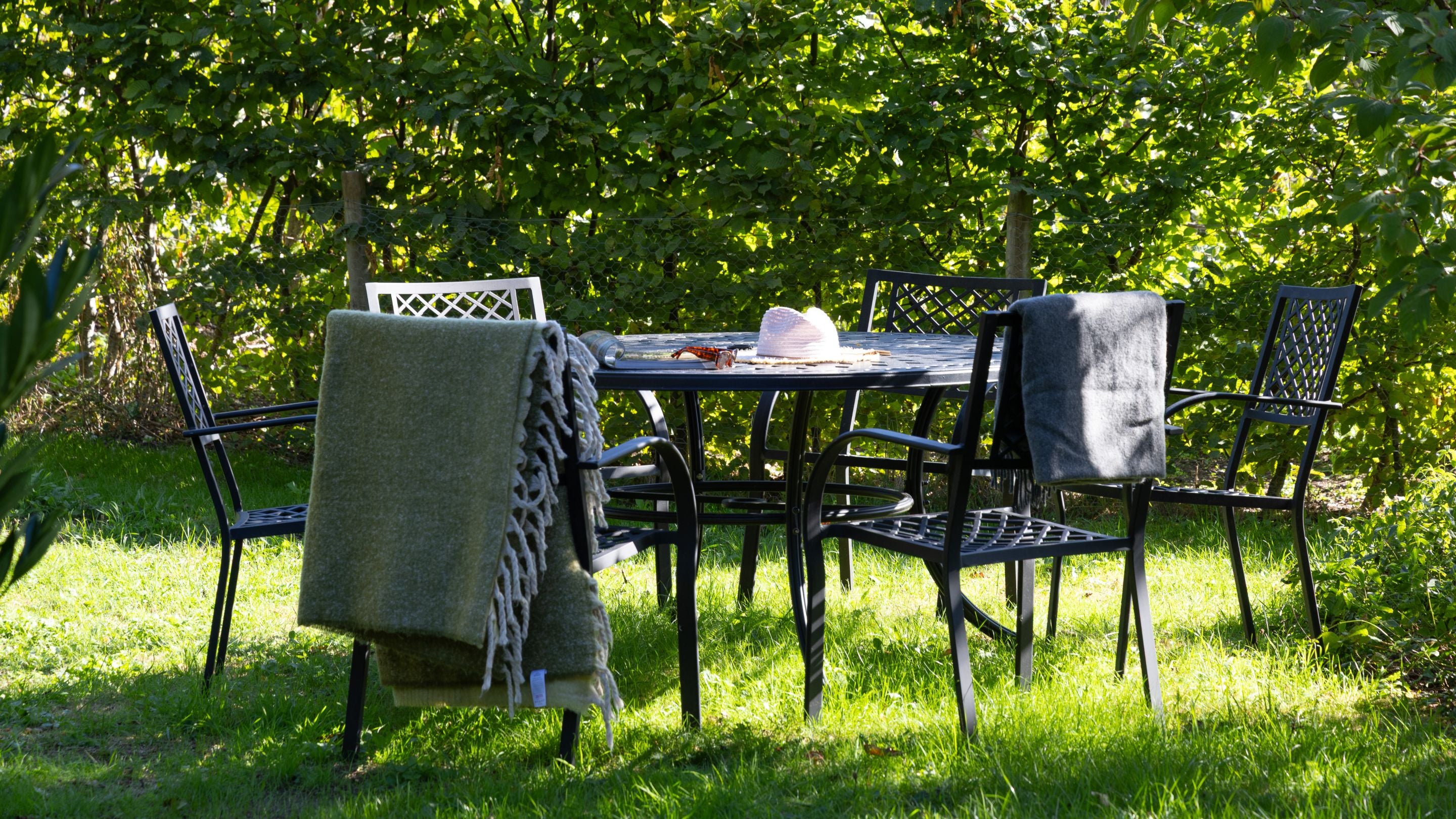Outdoor dining furniture on the lawn of the private garden at Polesden Garden Cottage, Surrey