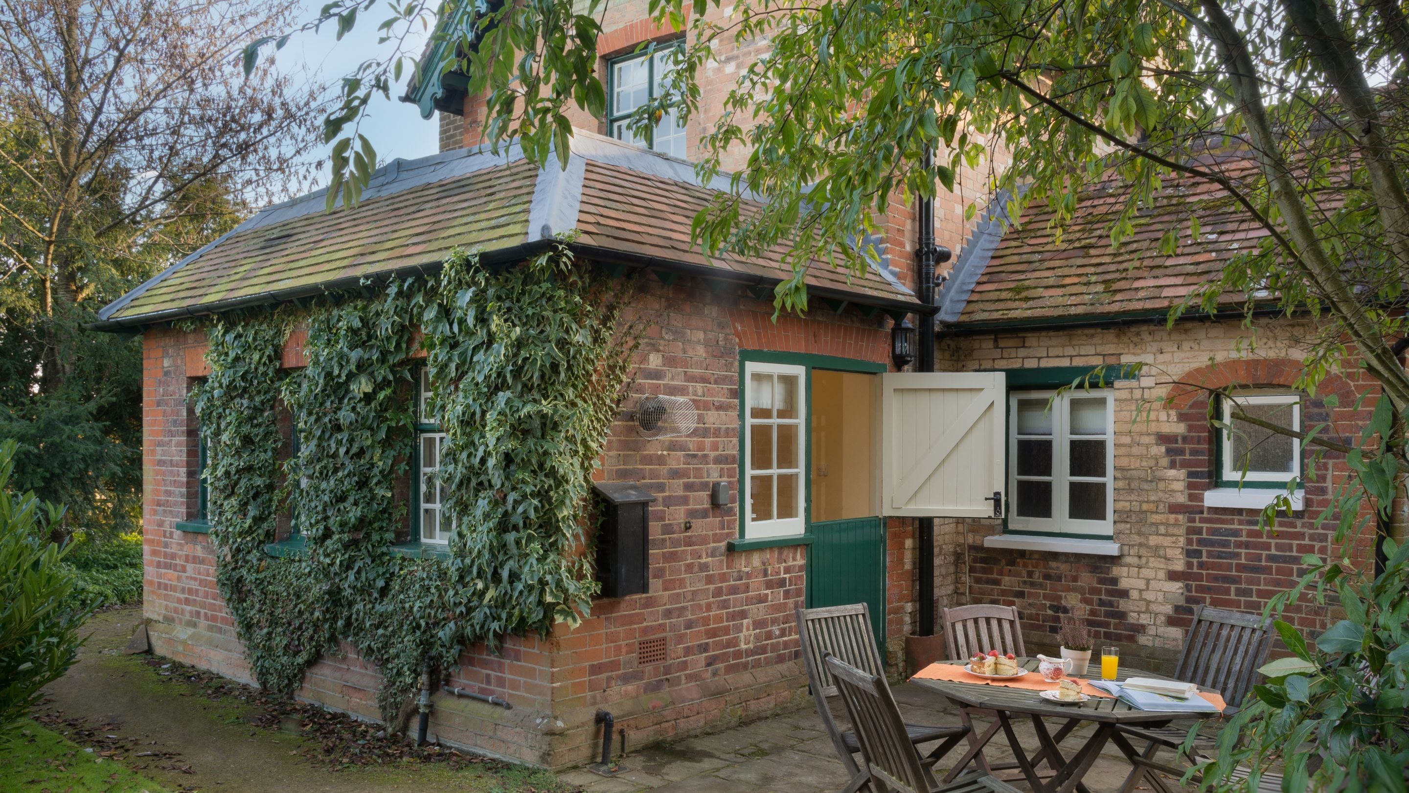 The patio with table and chairs in the private garden at Polesden Garden Cottage, Surrey