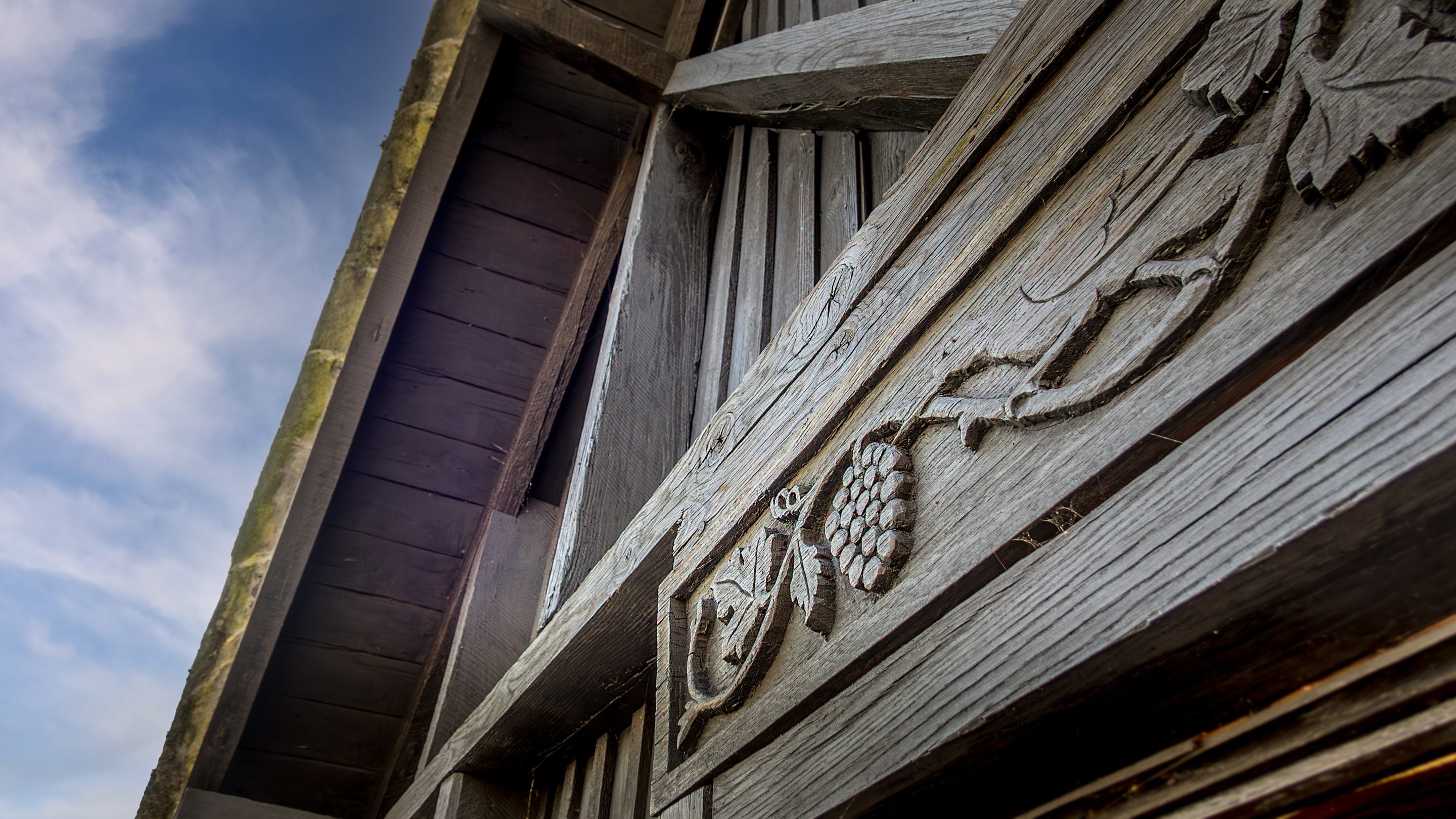 Strawberry plant design carved into the wood of the exterior of the first floor of High Strawberry Gardens, Cumbria