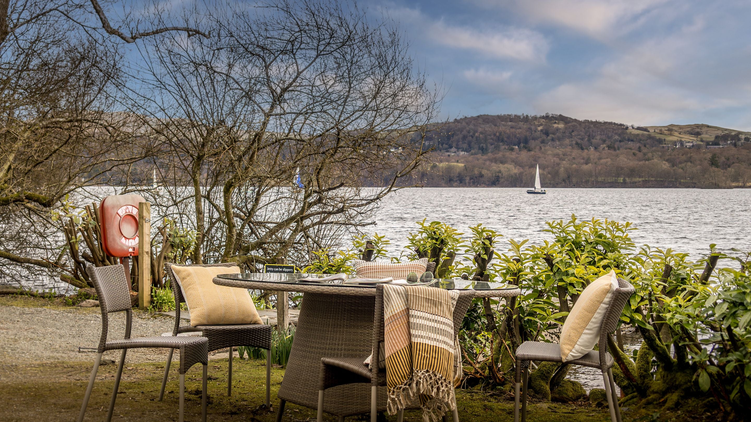 The table and chairs by the jetty on Windermere at Low Strawberry Gardens, Cumbria