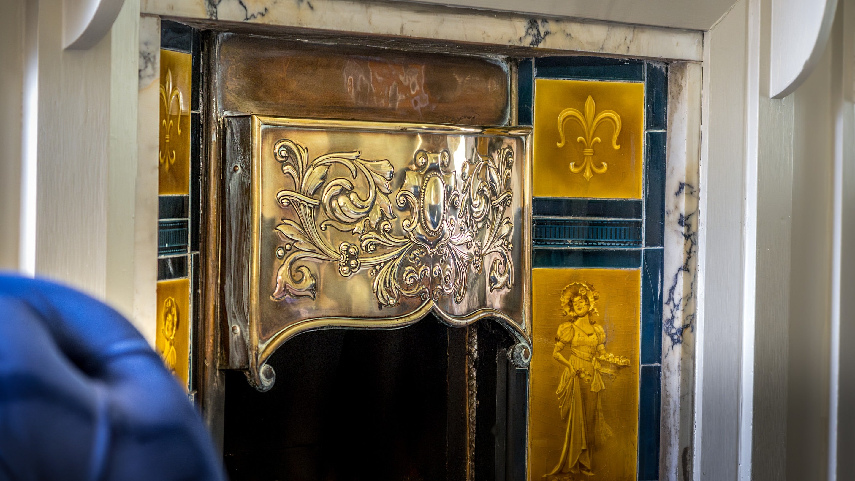 The original fireplace in the sitting room at Millbeck Towers, with copper work from the Keswick School of Industrial Arts, Cumbria