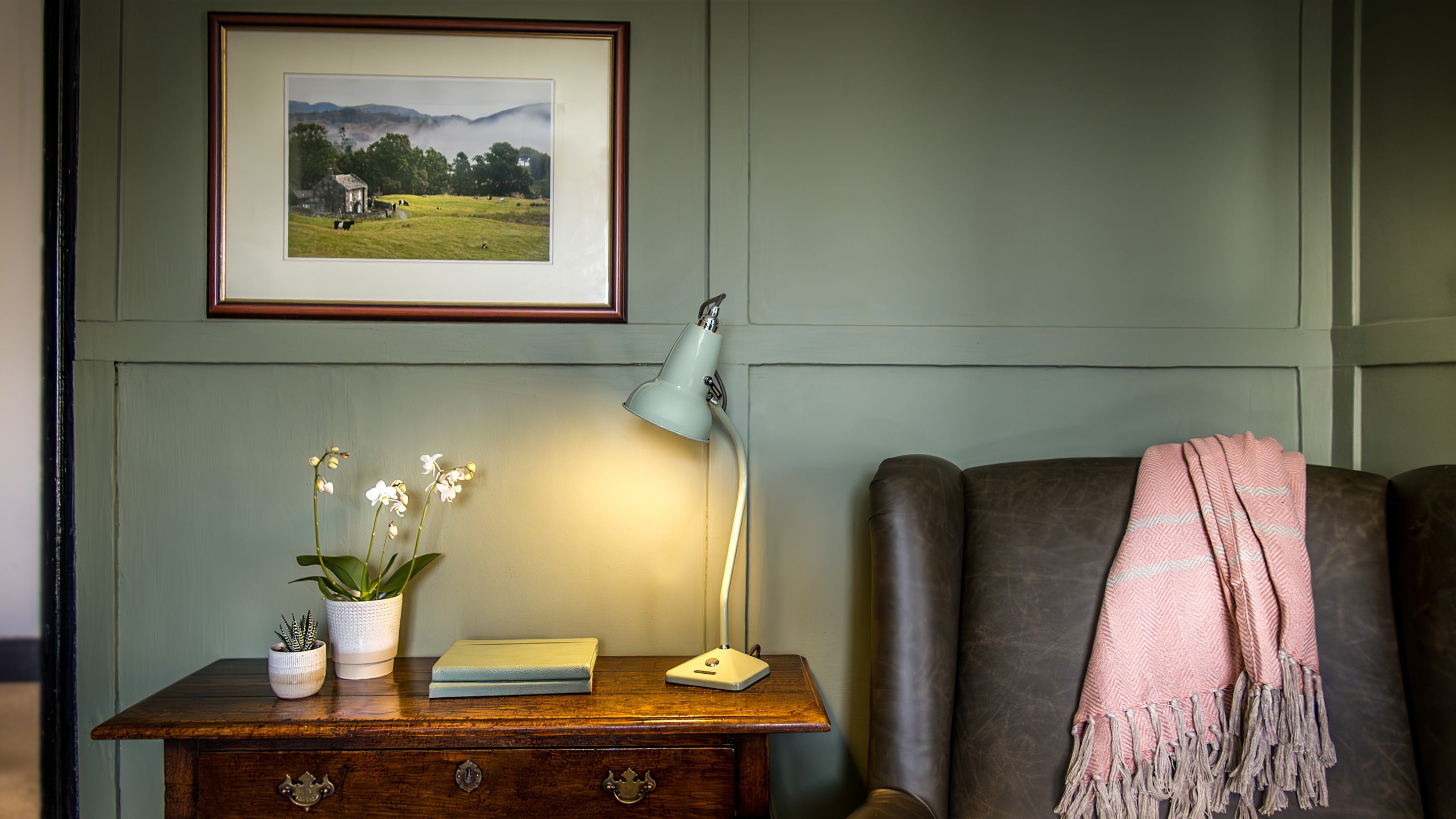 The side table and armchair in sitting room at Rose Castle Cottage, Cumbria