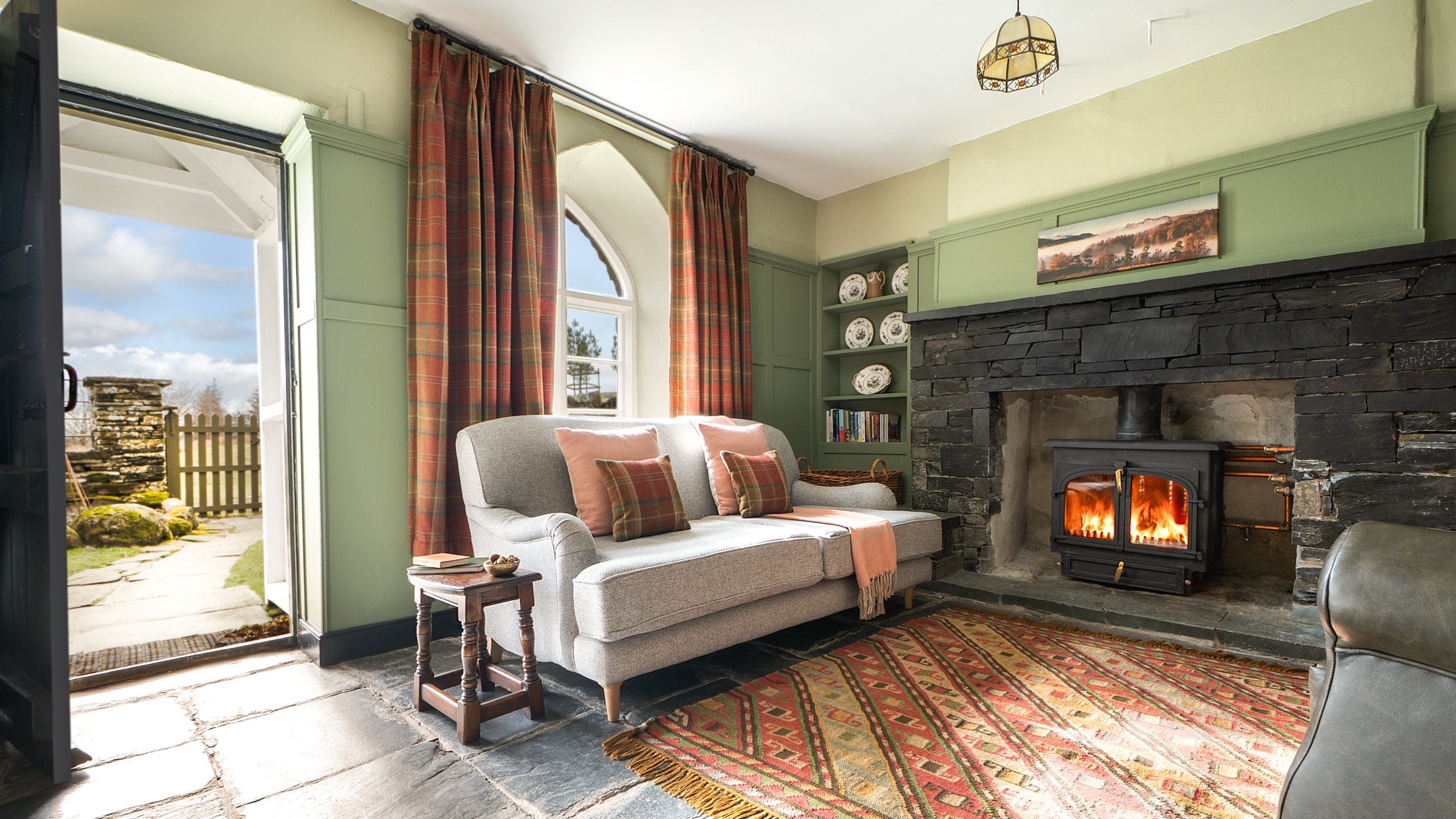 The sitting room with woodburner at Rose Castle Cottage, Cumbria