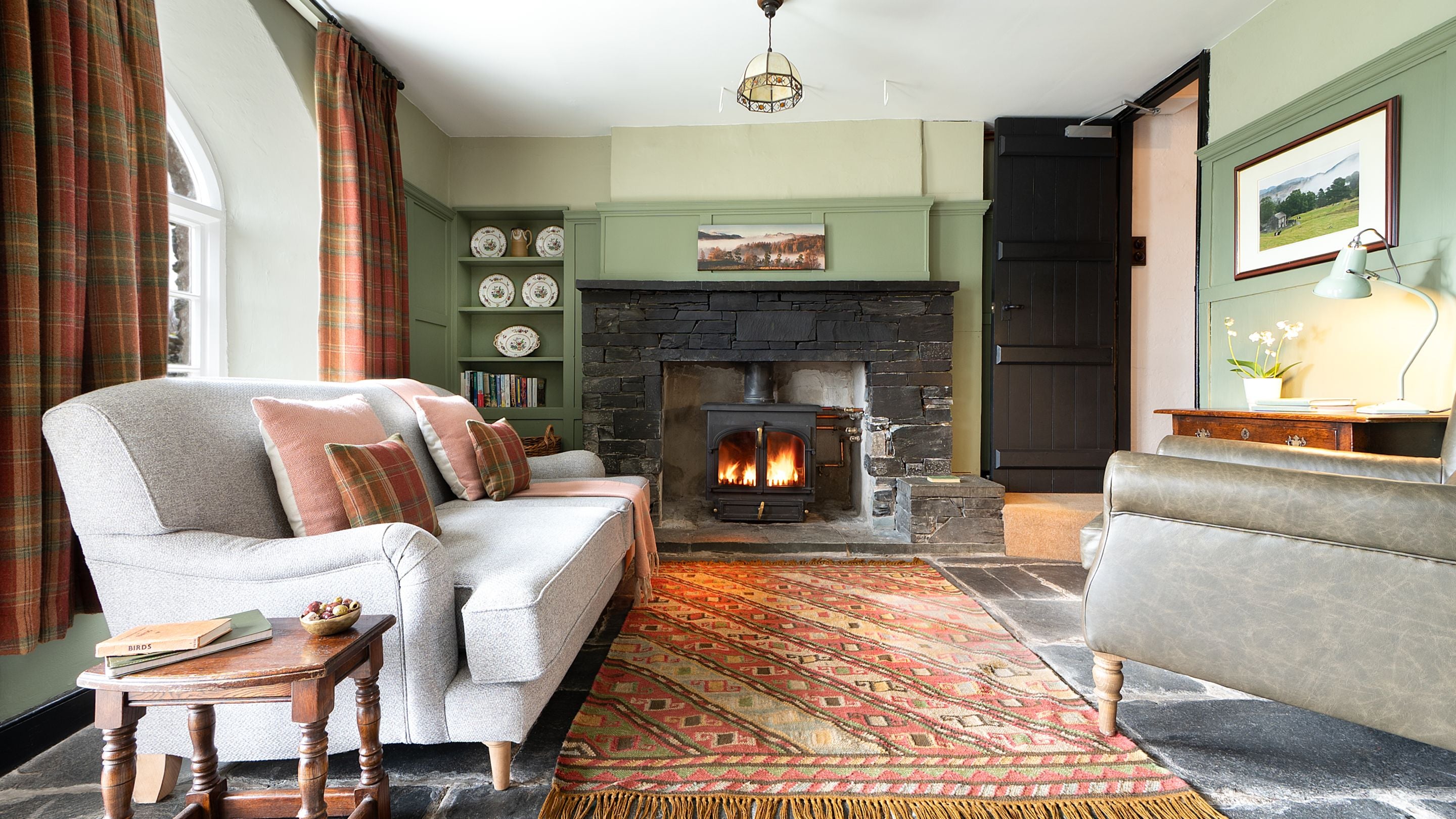 The sitting room with woodburner at Rose Castle Cottage, Cumbria