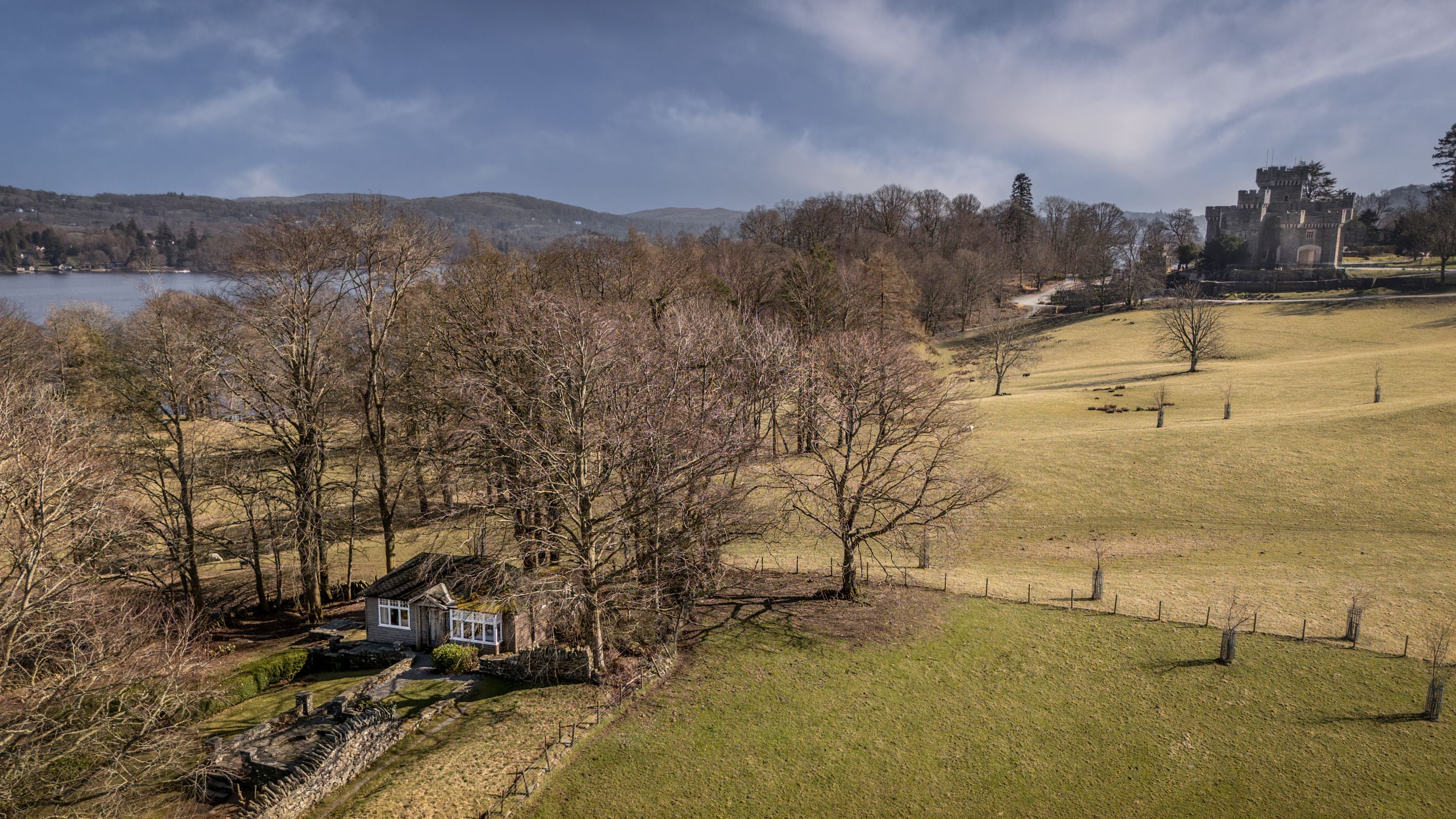 An aerial view of The Summer House, with Wray Castle and Lake Windermere in the background, Cumbria