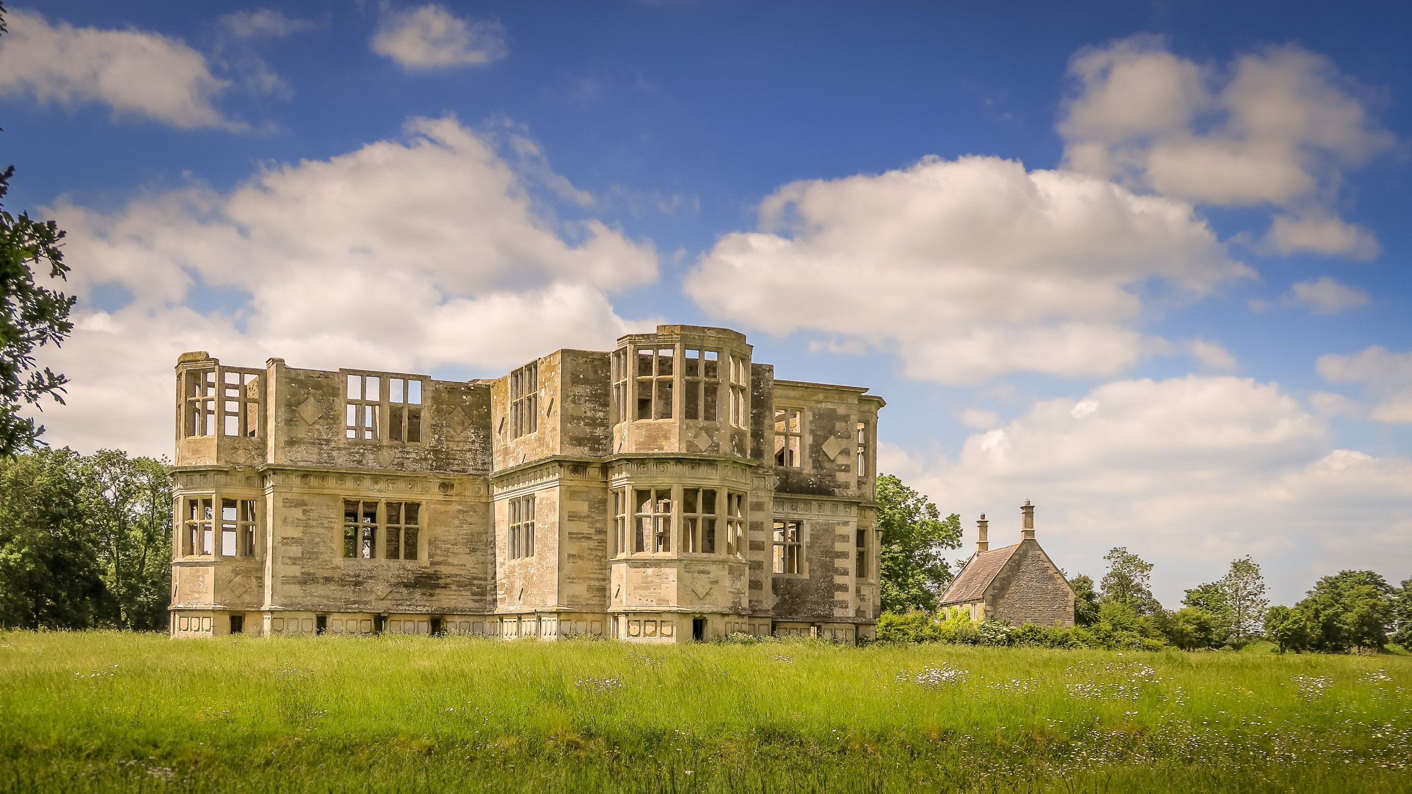 The unfinished Elizabethan structure of Lyveden Garden Lodge and Lyveden Cottage behind it, Northamptonshire