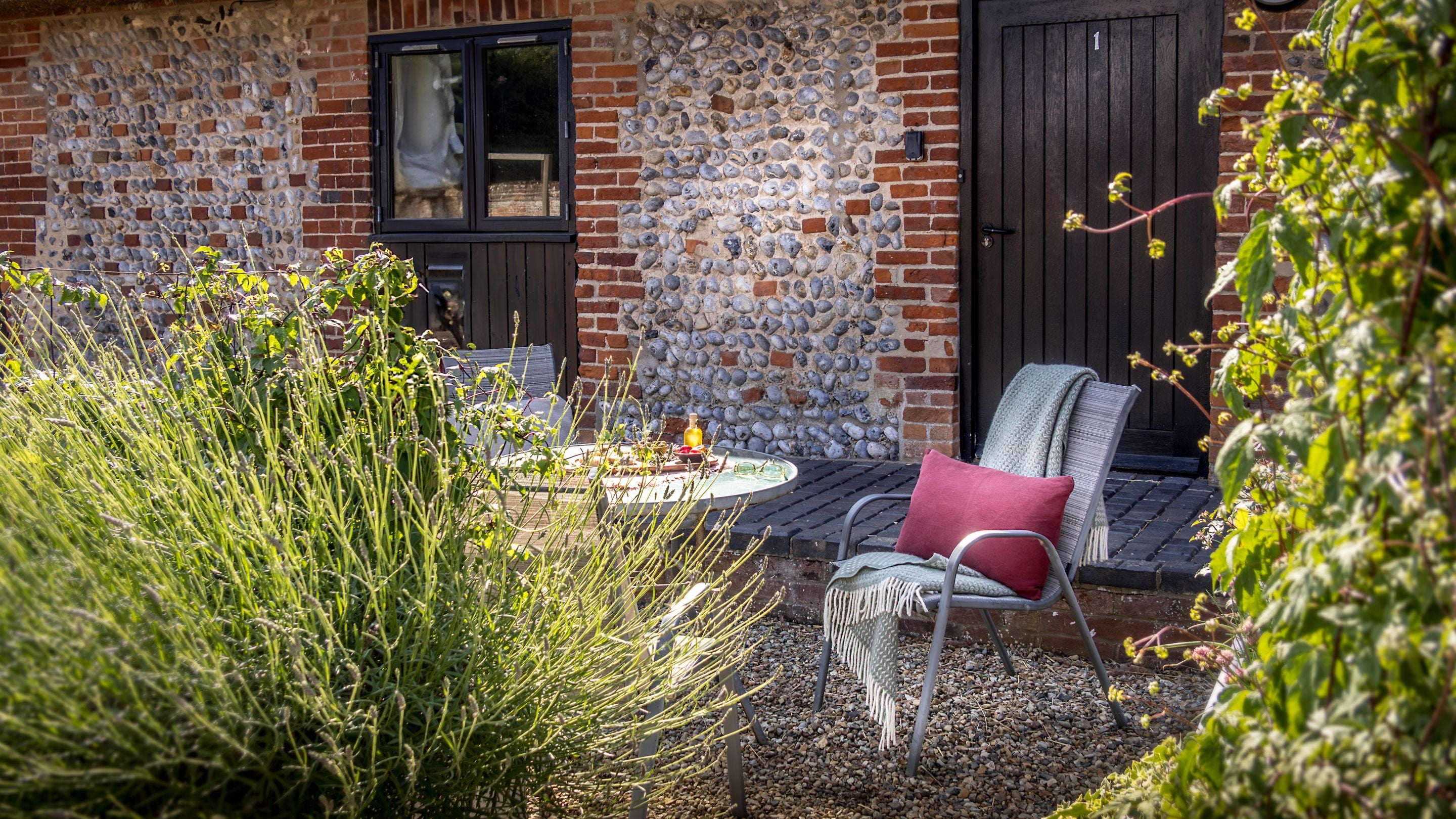 The front of 1 Horsey Barns and its outdoor dining furniture, Norfolk