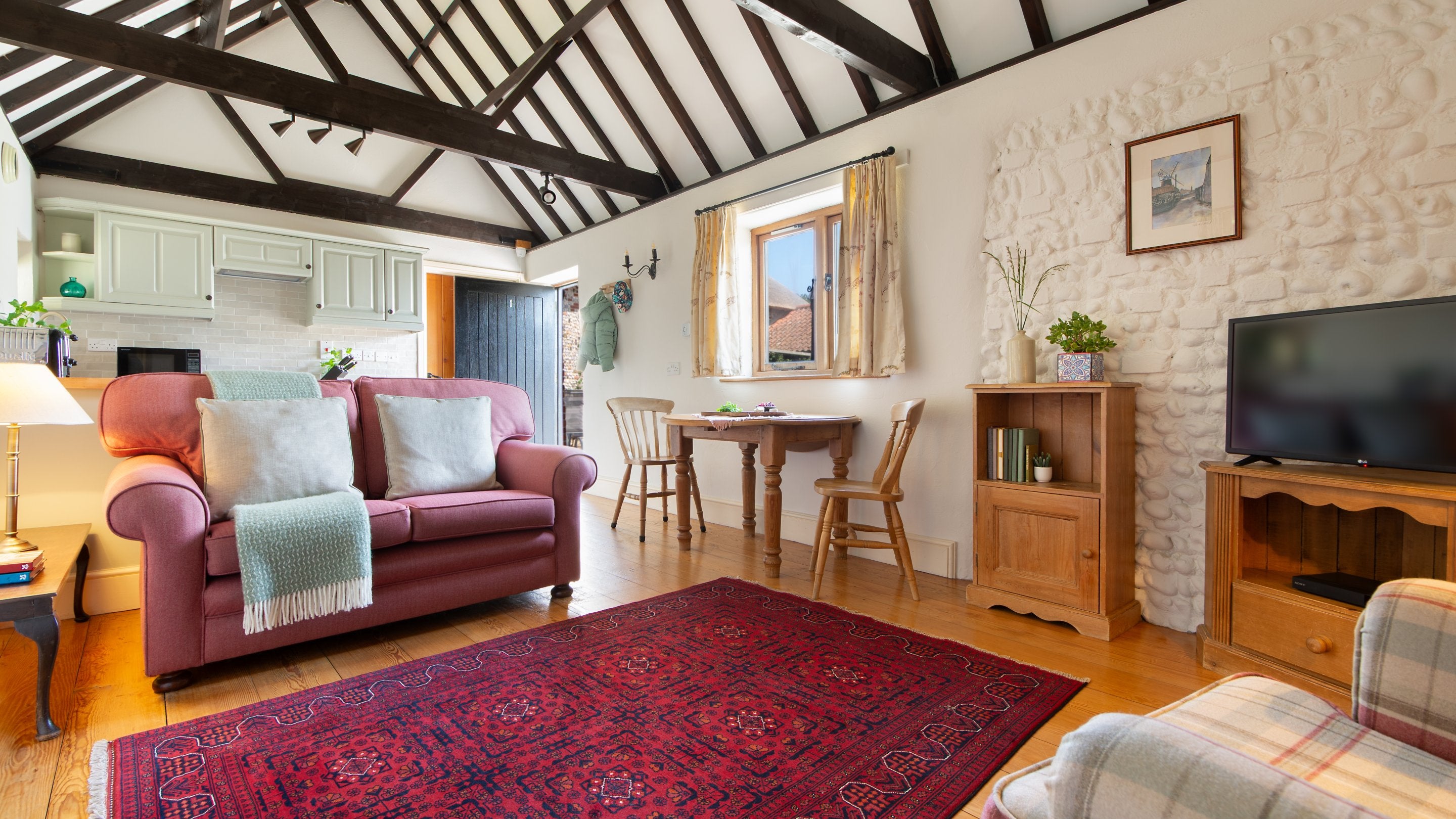 The open-plan kitchen, dining and sitting room with vaulted ceiling at 1 Horsey Barns, Norfolk