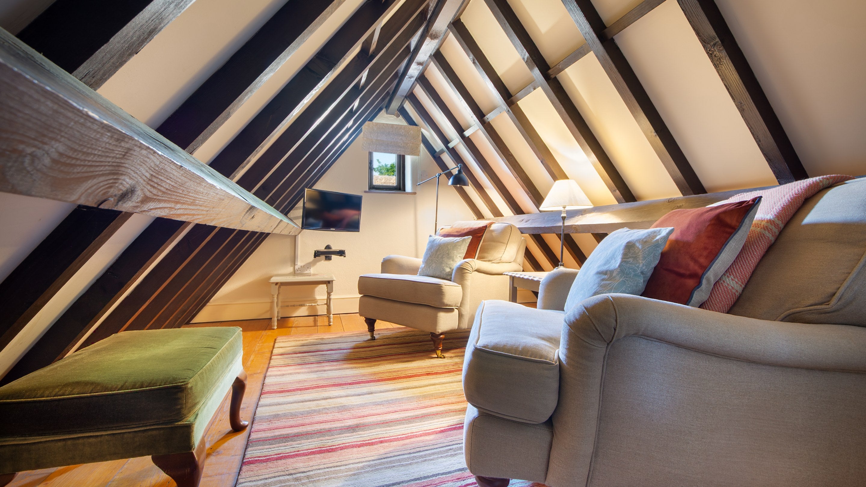 The mezzanine reading room, with sloped ceilings and restricted height, on the first-floor of 2 Horsey Barns, Norfolk