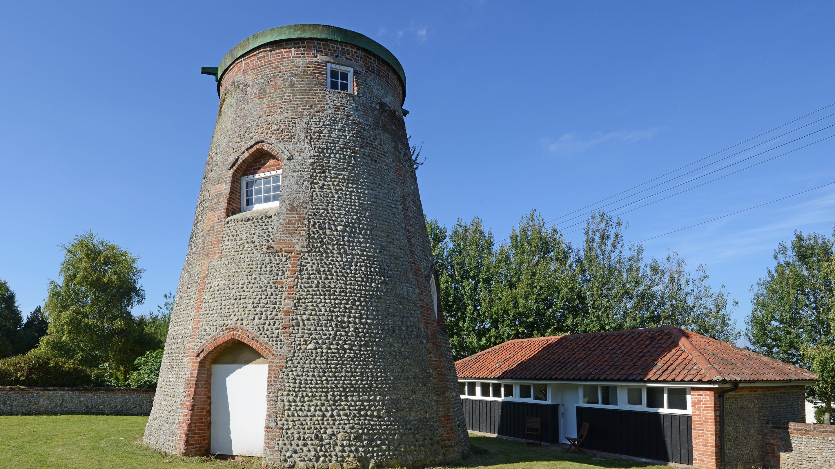 An exterior view of Blakeney Lodge and the old windmill in Norfolk