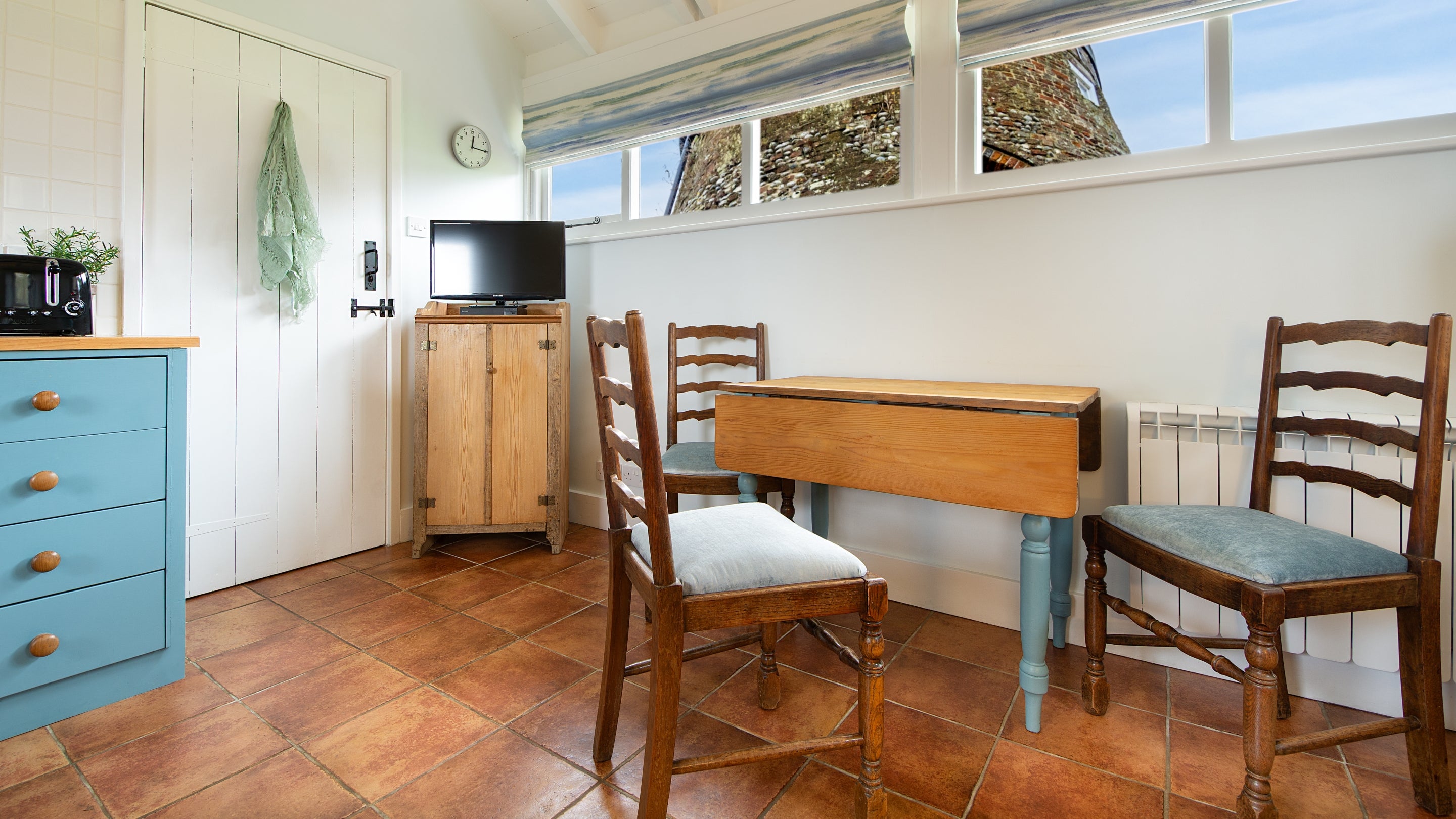 The dining area in the open-plan living space at Blakeney Lodge, with views of the windmill, Norfolk