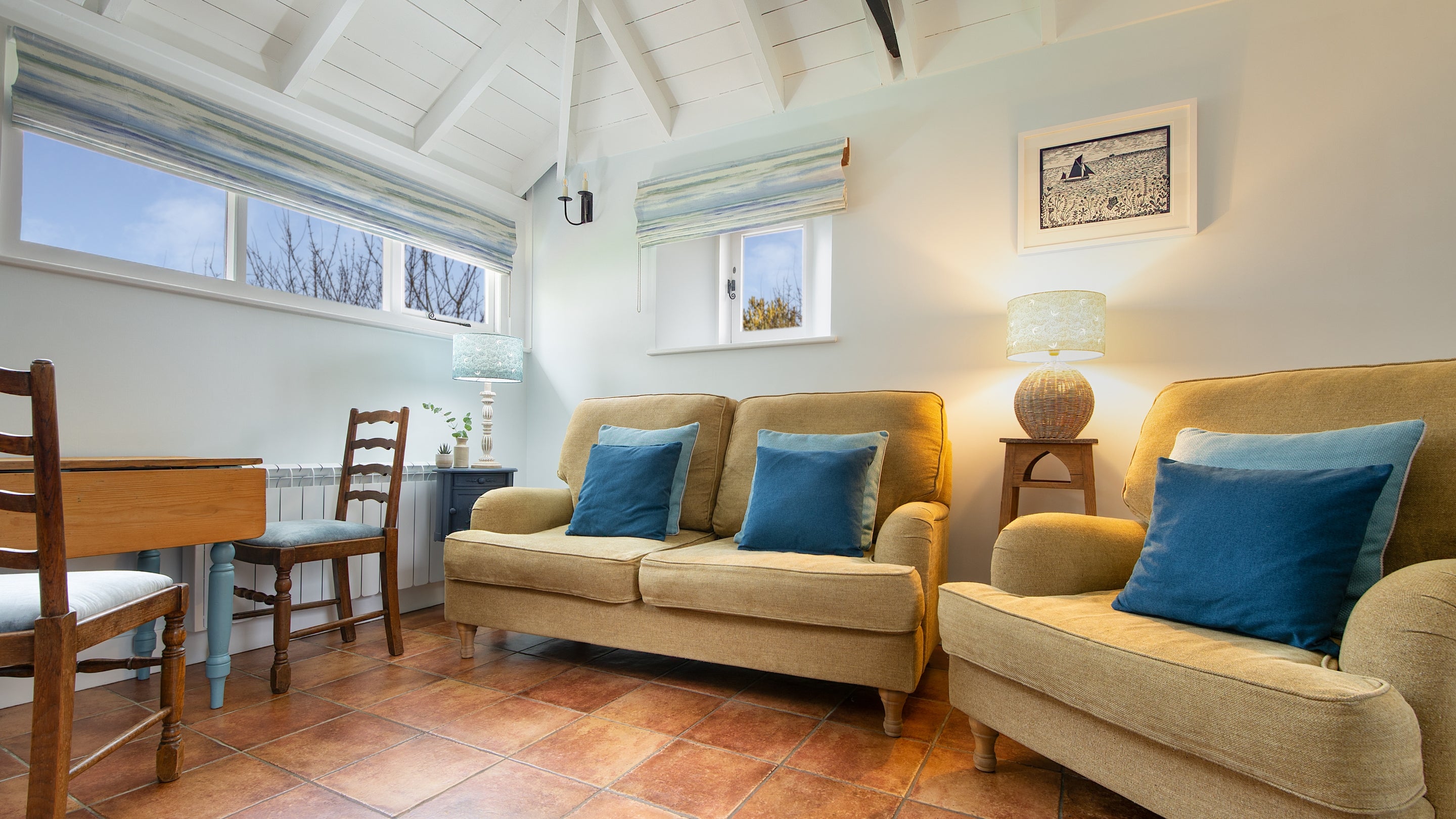The seating area in the open-plan living space with a sofa and armchair at Blakeney Lodge, Norfolk