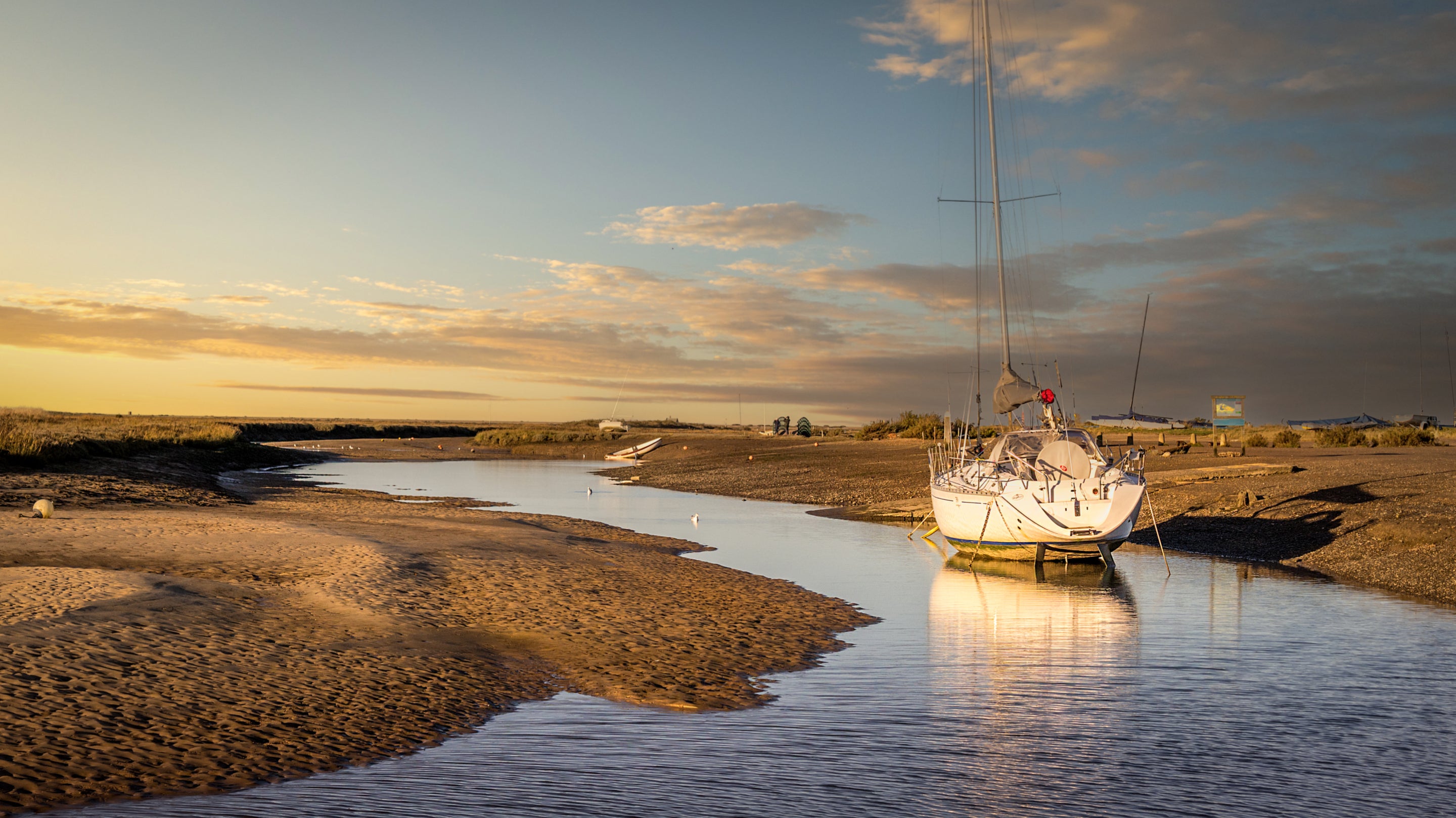 A boat docked on the tidal creeks at Blakeney Quay, near Blakeney Lodge, Norfolk