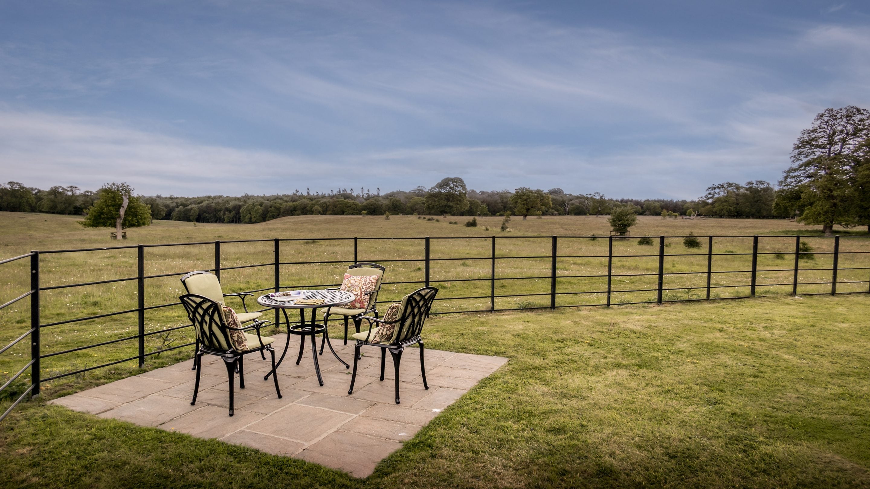 The ground-level patio with a table and four chairs, and the fenced area of lawn around Blickling Tower, Norfolk