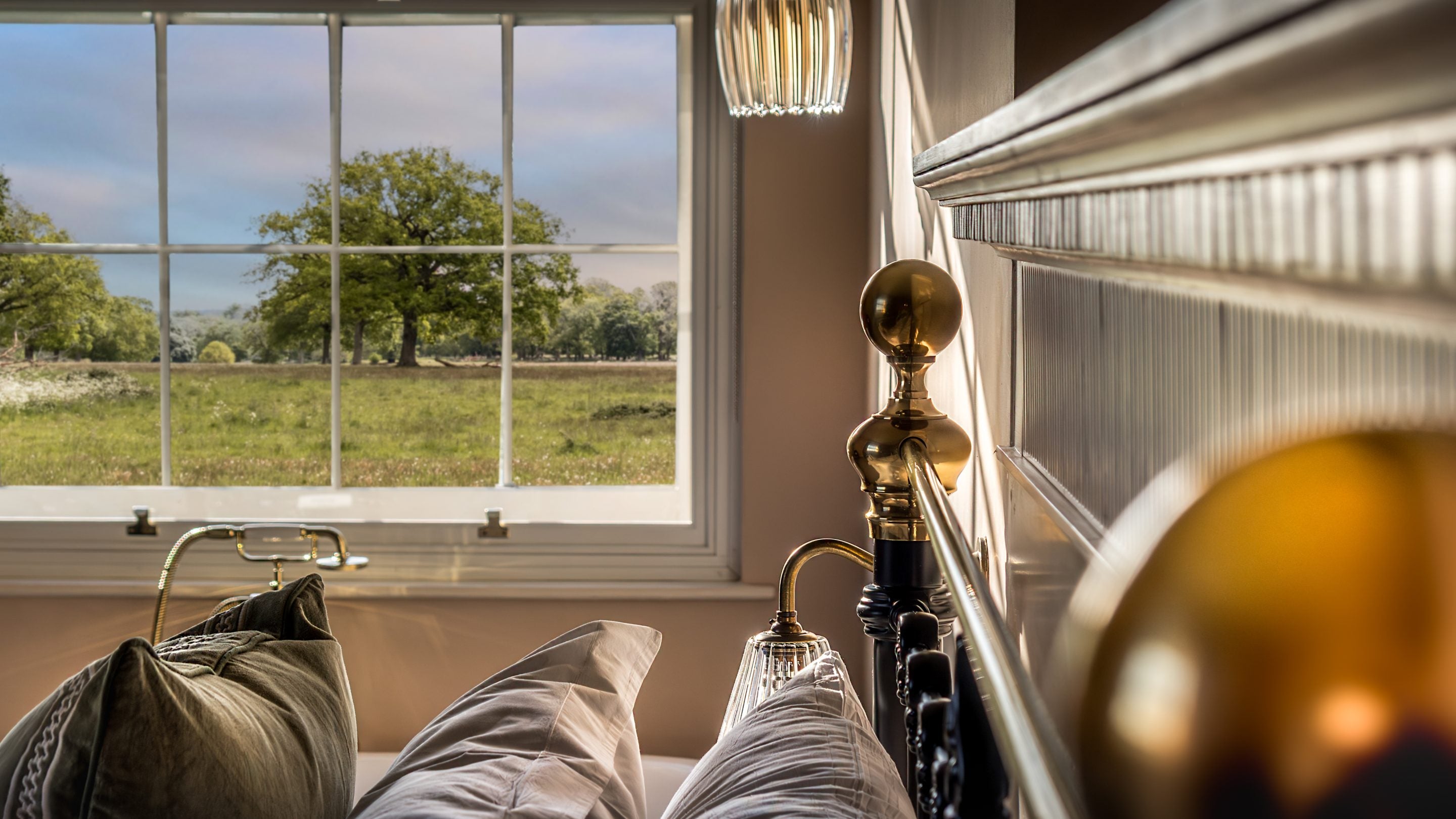 The view from the second-floor main bedroom looking out to the parkland and a large tree at Blicking Tower, Norfolk
