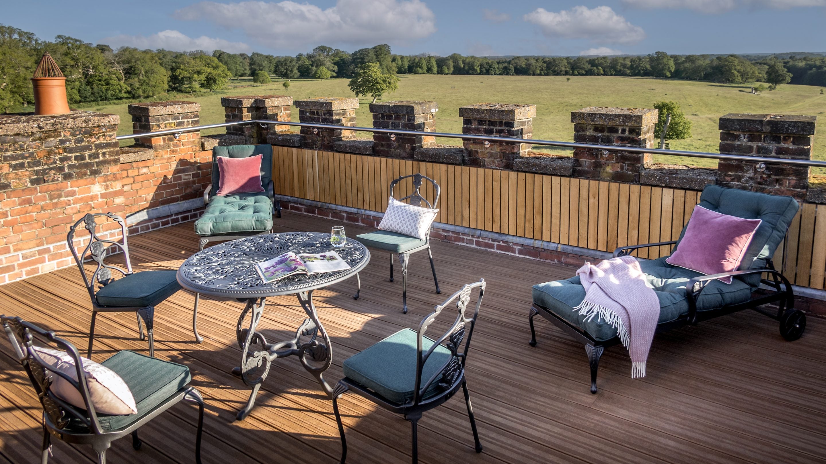 The roof terrace at Blickling Tower in Norfolk with a table, four chairs and two loungers