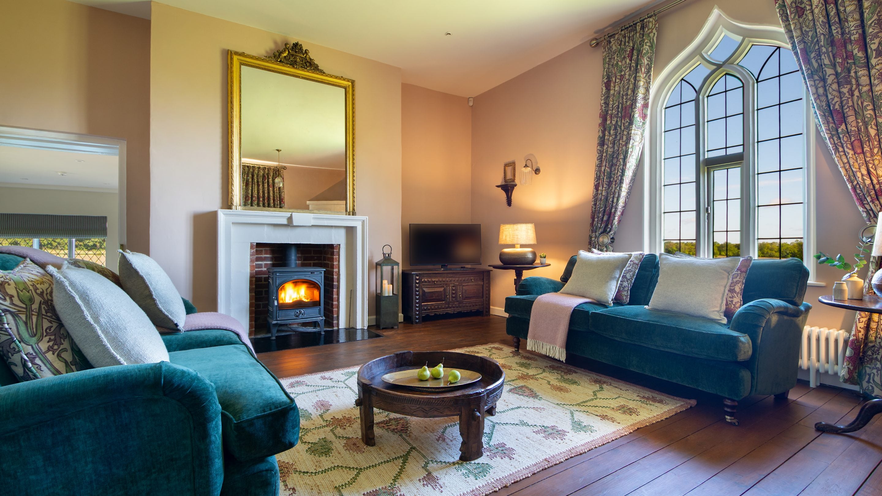 The sitting room in Blickling Tower, a self-catering holiday rental on the Blickling Estate for four guests, with a woodburner, sofas and a large window, in Norfolk
