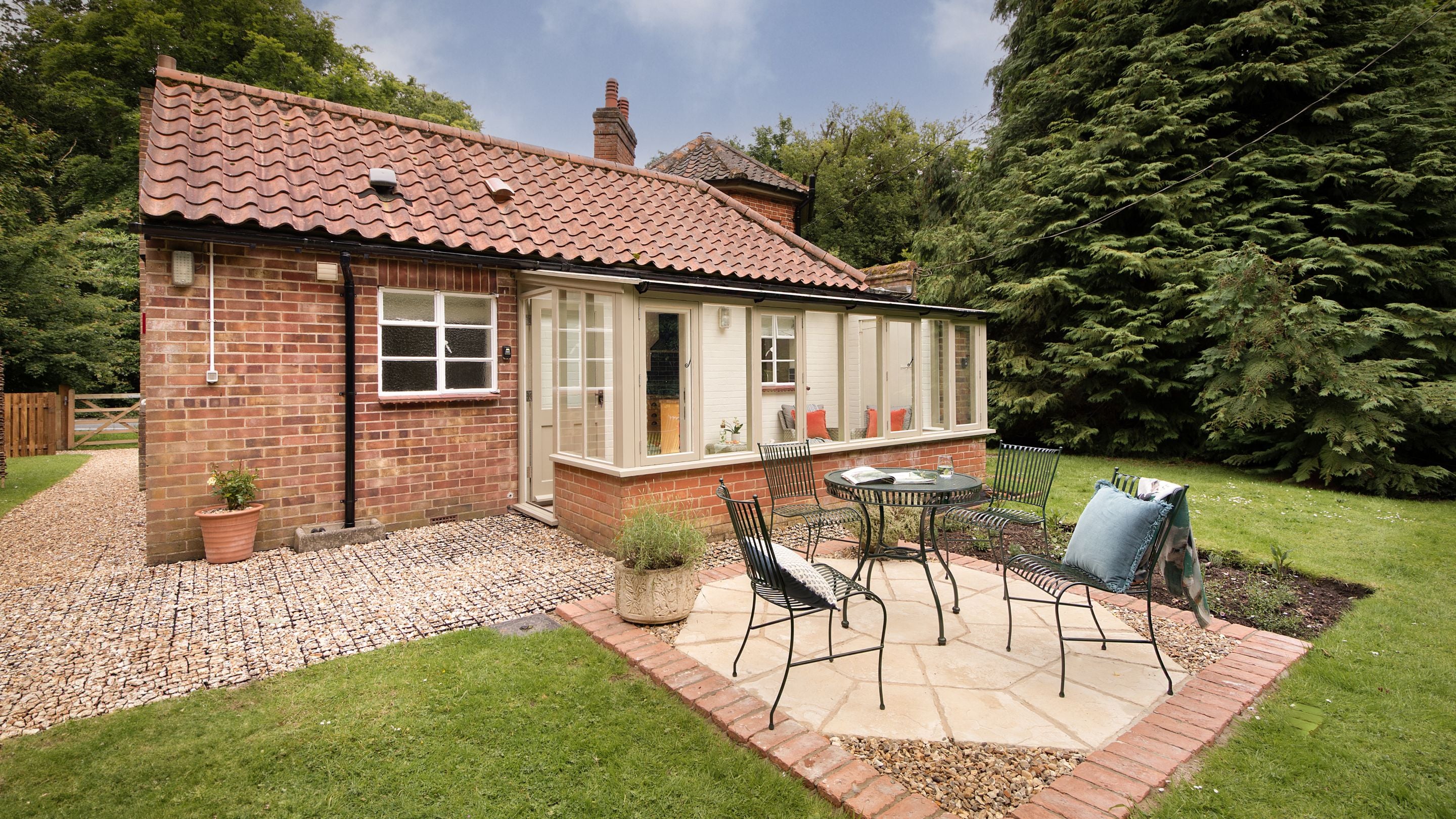 The patio with outdoor dining furniture in the garden at Mustard Pot Cottage, Norfolk